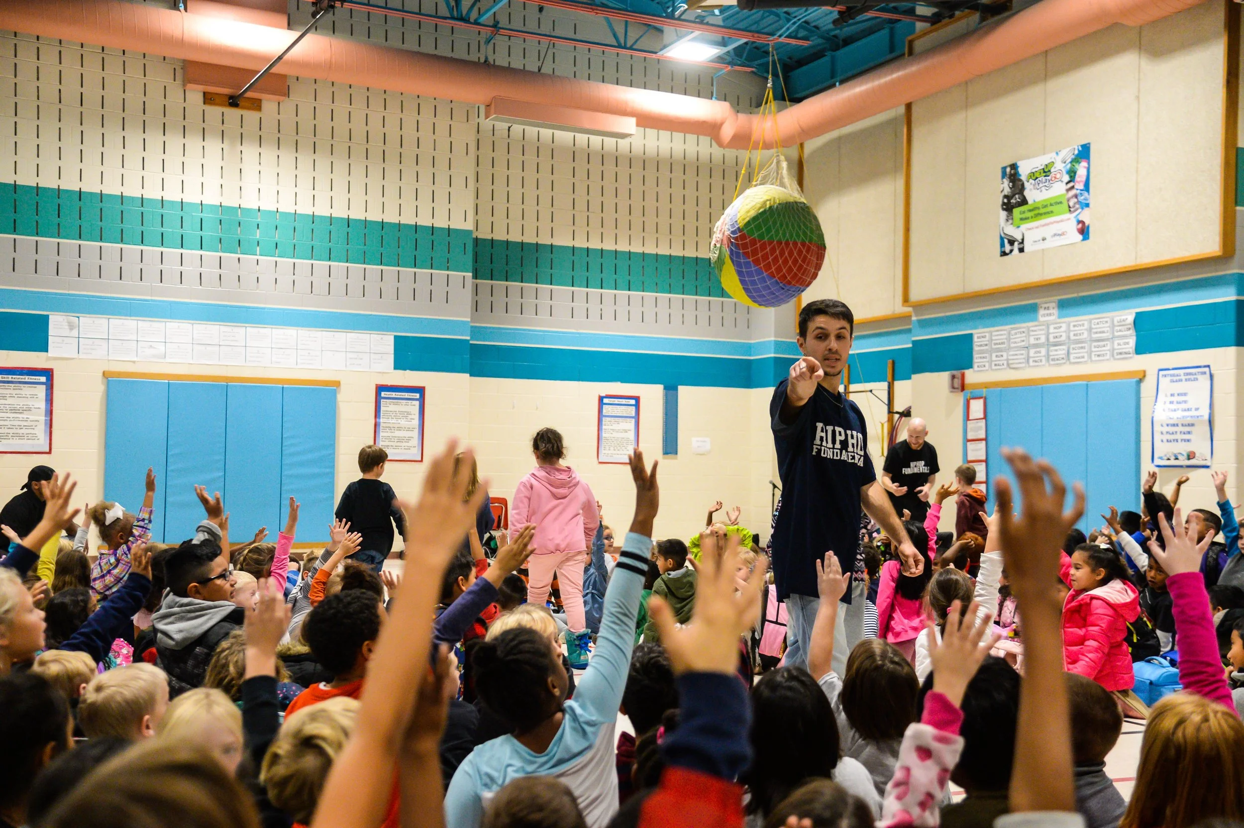 Children raise their hands for a chance to participate