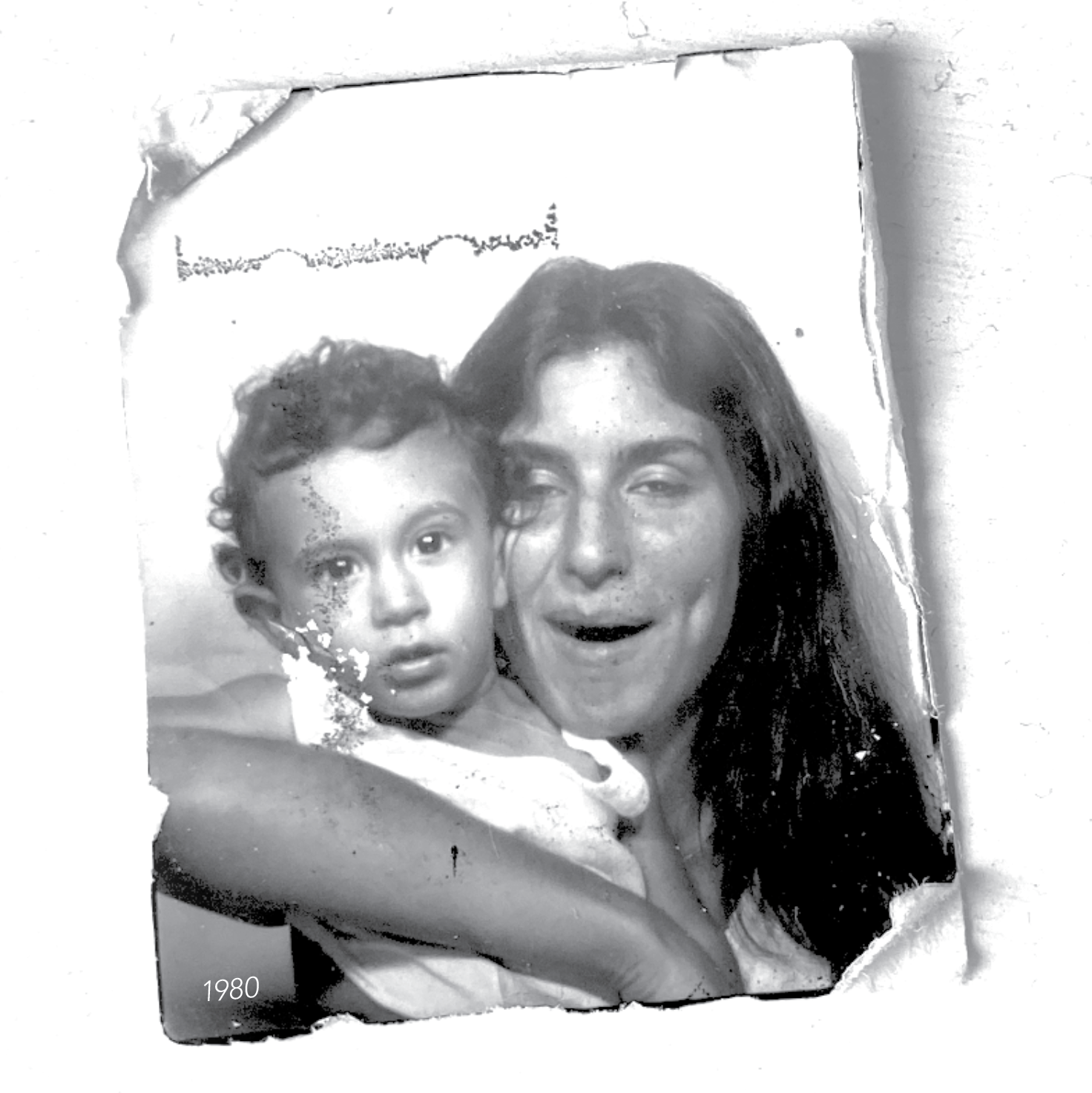 Black and white photo of a woman holding a young child, 1980.