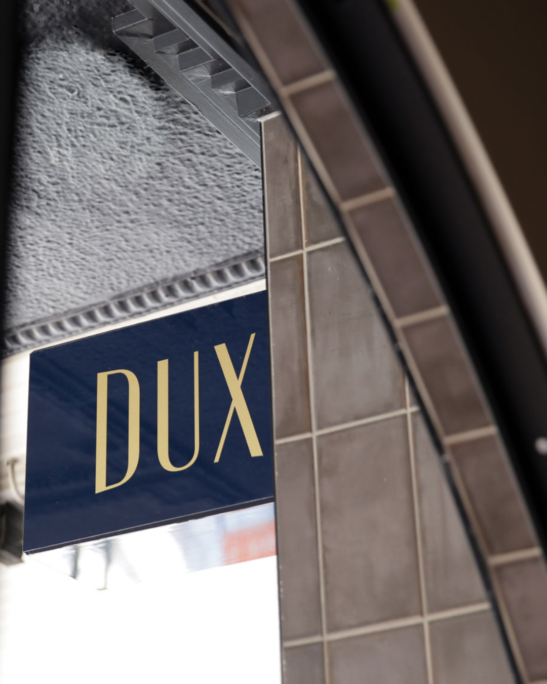 Navy blue signage that reads Dux