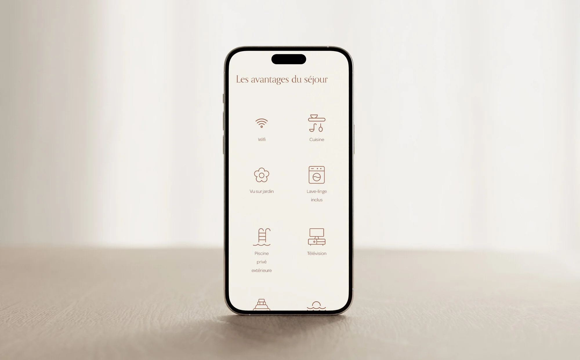 Smartphone affichant une liste d'avantages pour le séjour, incluant Wifi, cuisine, vue sur le jardin, lave-linge inclus, piscine privée extérieure, télévision.