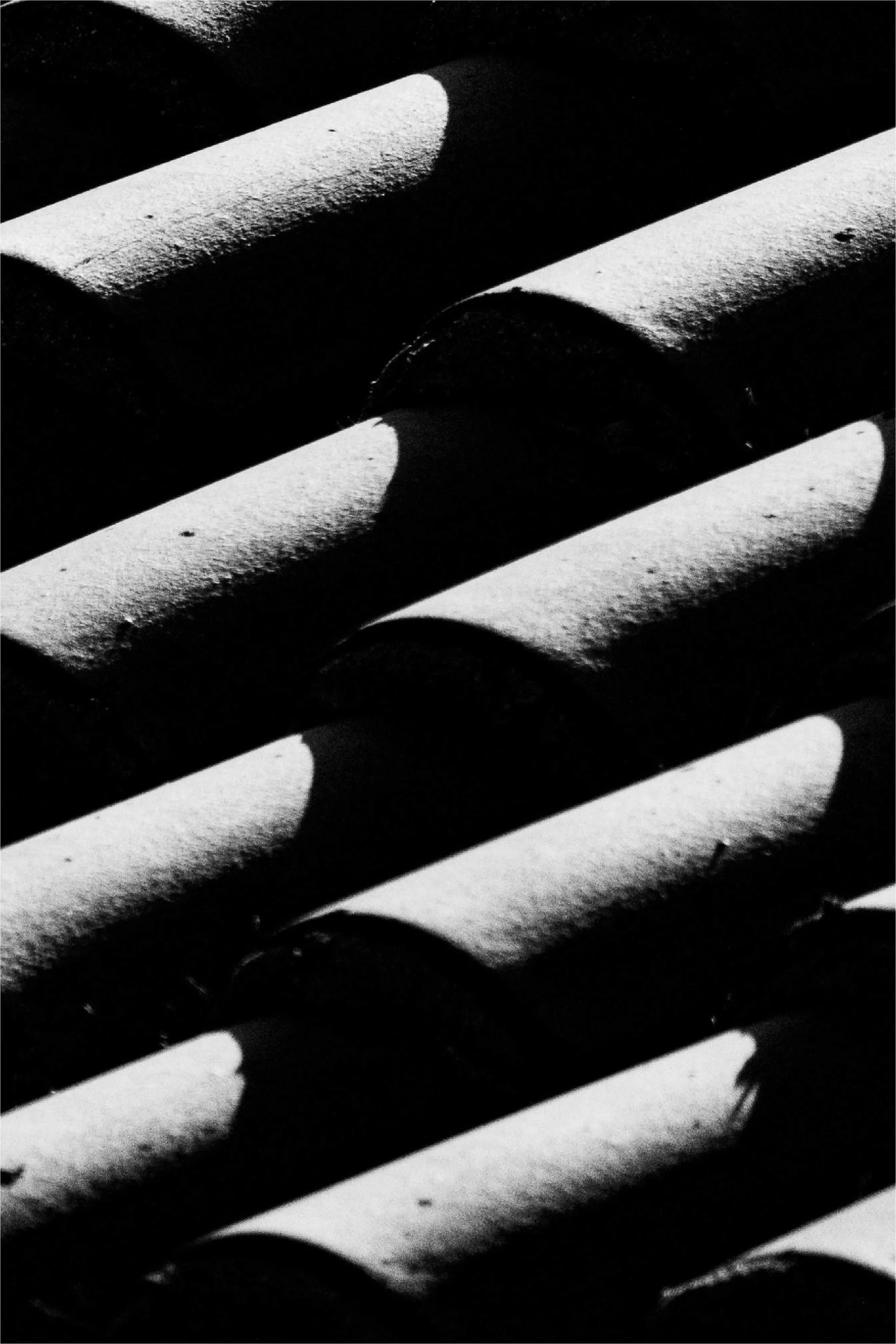 Tuyaux de plomberie en métal avec des ombres et des lumières contrastées.