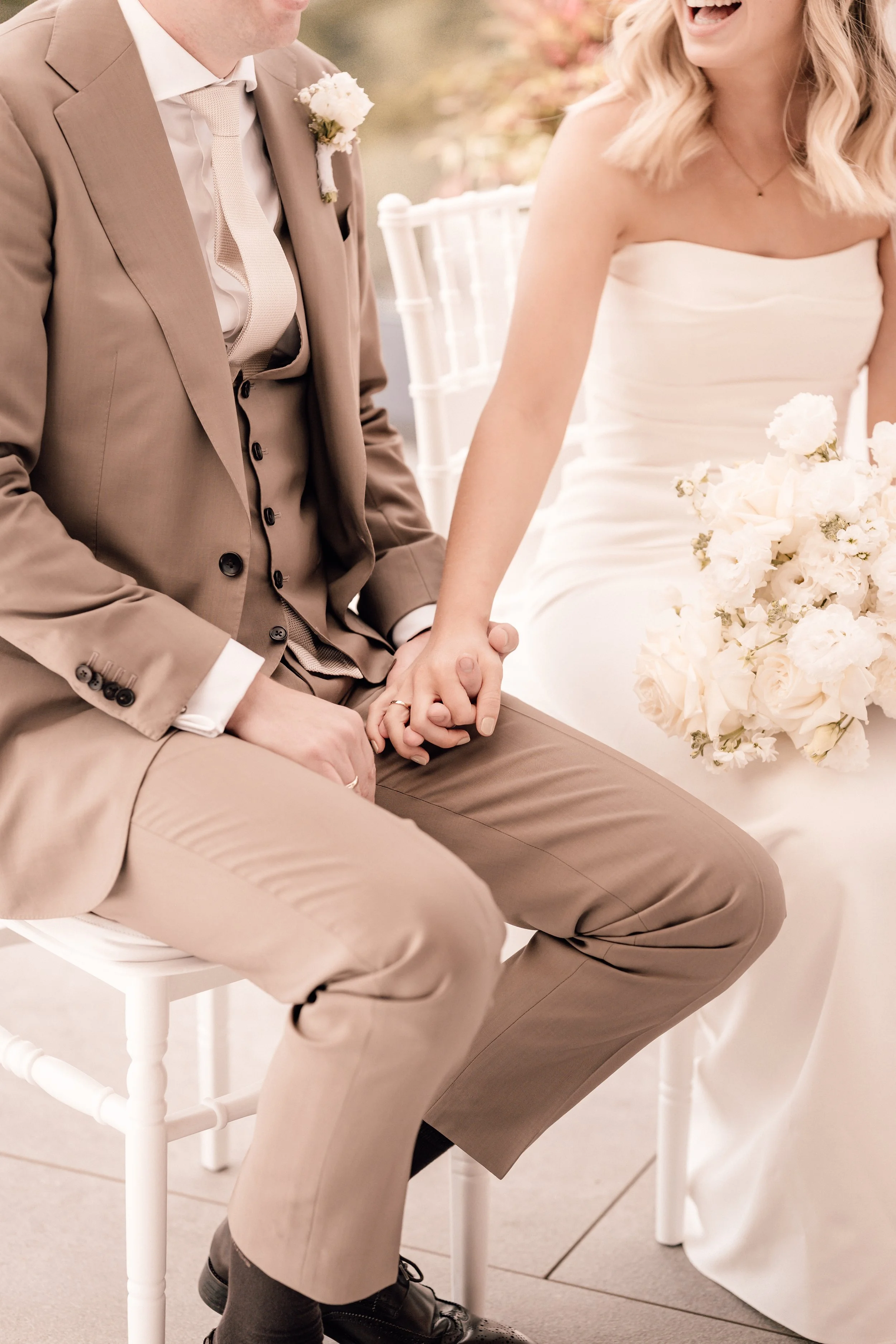 Ein Brautpaar hält Händchen bei einer Hochzeit, das Brautkleid und der Anzug sind sichtbar. Sven Goos Fotografie