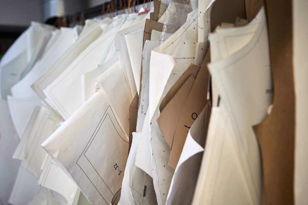 Paper patterns hanging on a rail.