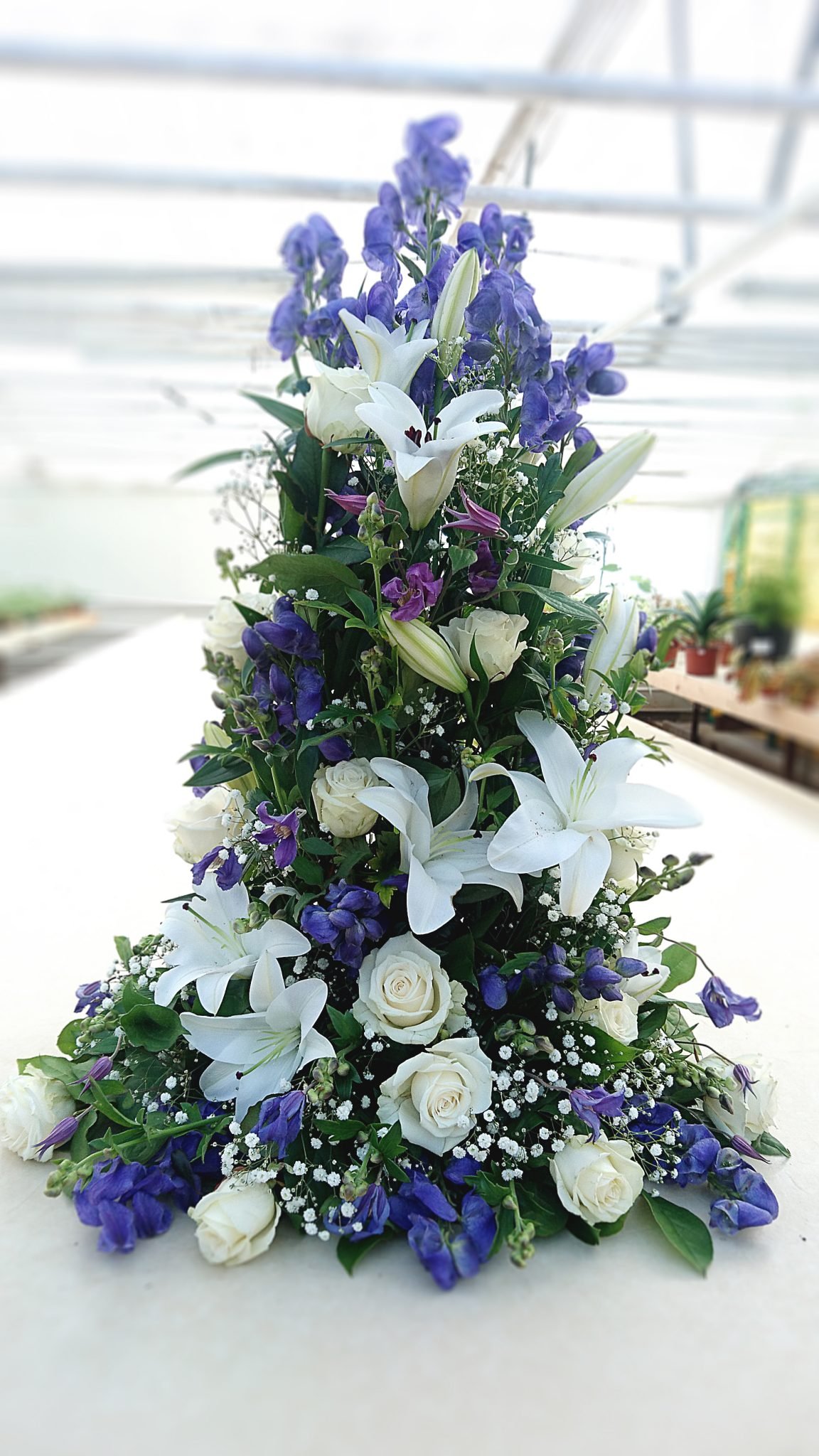 Hög begravningsblomma / kistdekoration med blå och vita blommor.