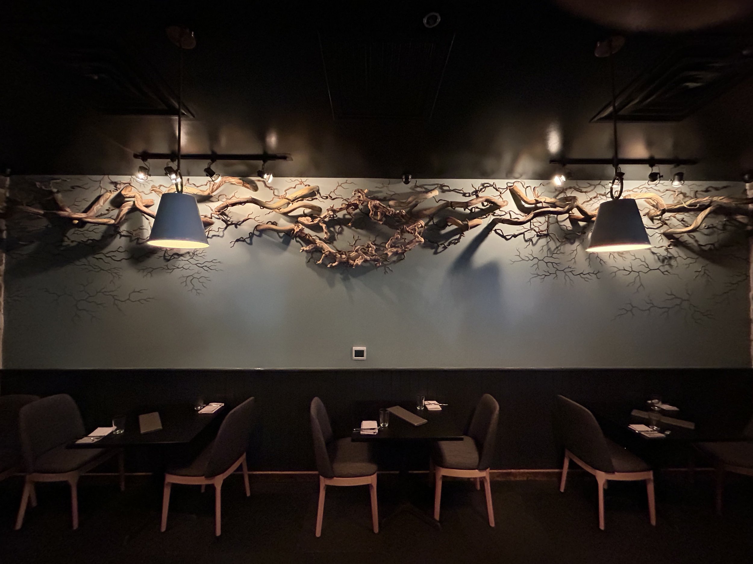 Sculptural installation of vine structure coming through the walls of a restaurant.  Using swimming noodles as big branches of roots, rope wrapped in wire as smaller ones, and wall caulk along with paint to simulate the texture of smaller ones just b