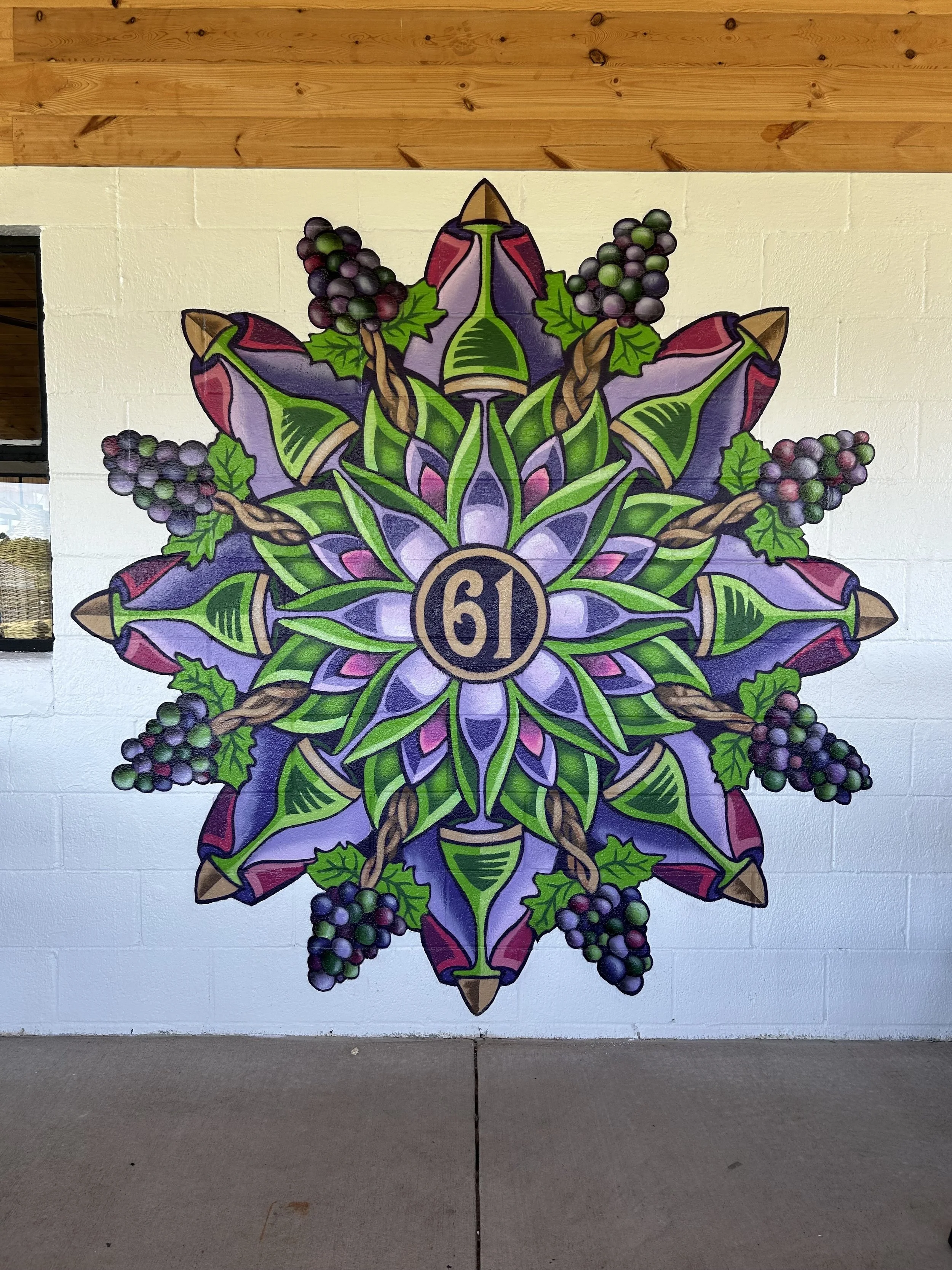 61 Vineyard in Damascus, MD.  Spray paint.  A fun decorative mandala with color celebrating the veraison of grapes, along with glassware and vines and grapes as tribute to the locality