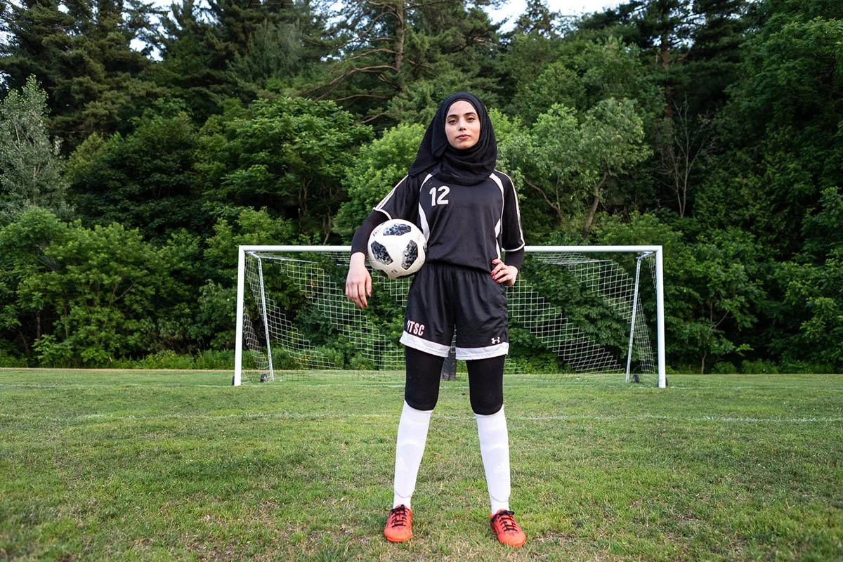 Batool está confiante em um campo de futebol.