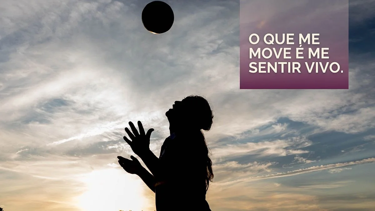 silhouette of a male soccer player looking up at a soccer ball