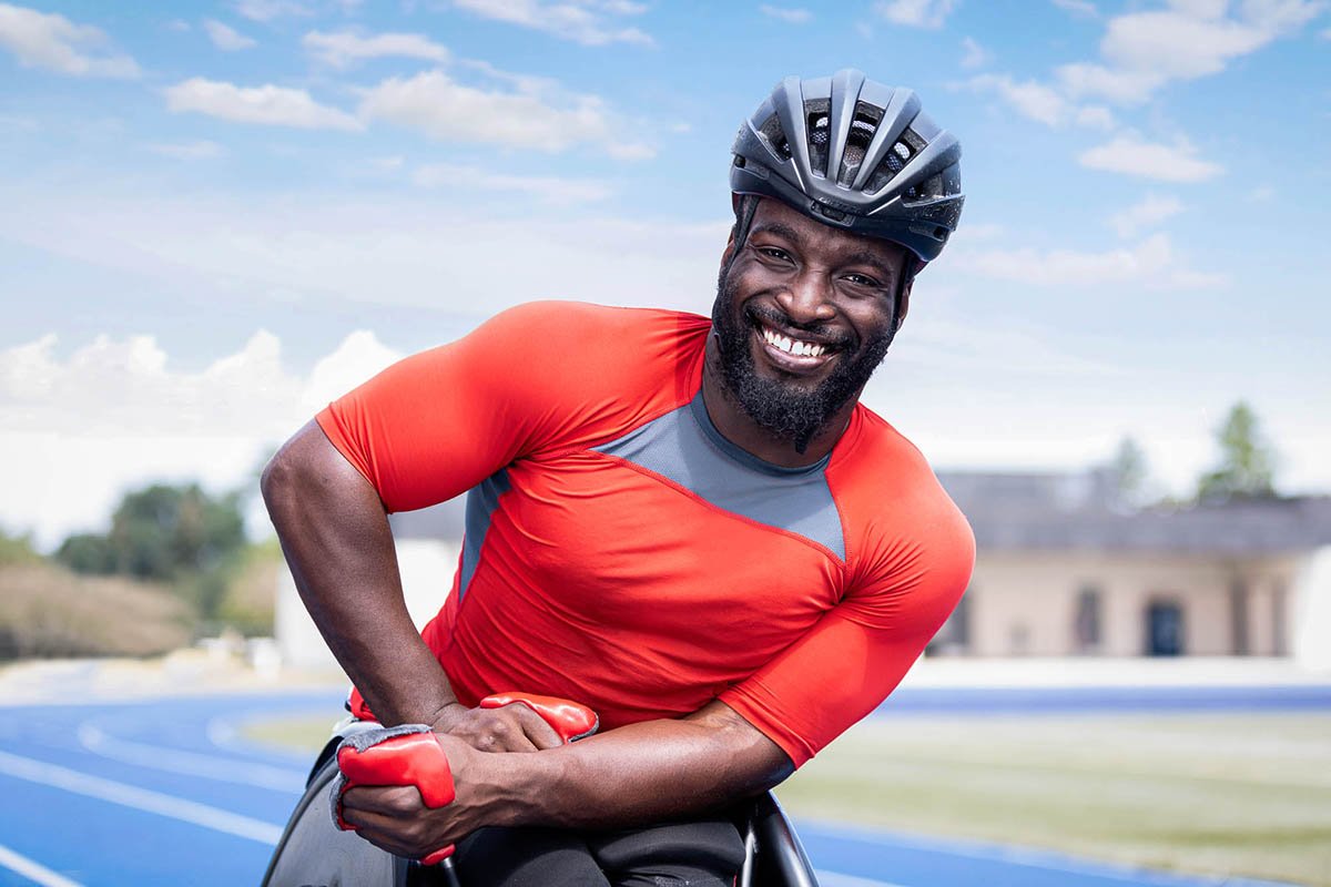 Isaiah a competitive wheelchair racer smiles in his racing gear