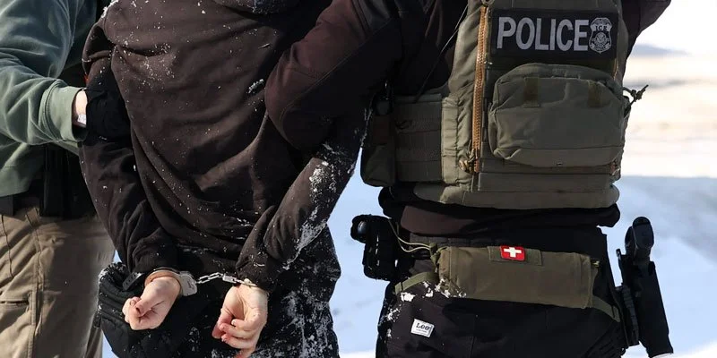 ICE agents detaining a man