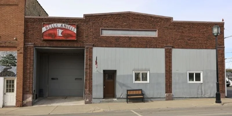 A red brick building with a Hells Angels sign mounted above the door