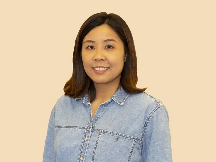 A black and white photo of a glass window reflecting buildings and bicycles, with large white text that reads "COMING SOON".