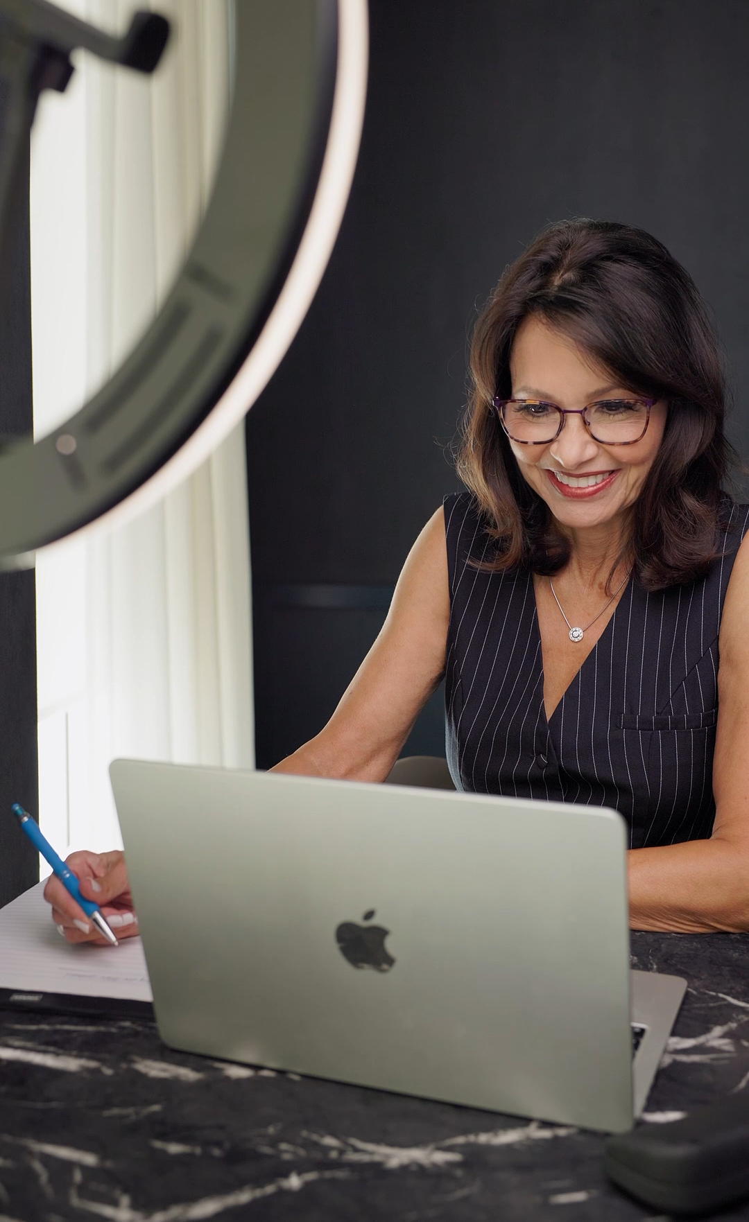 Liz Brunner looking at her laptop smiling