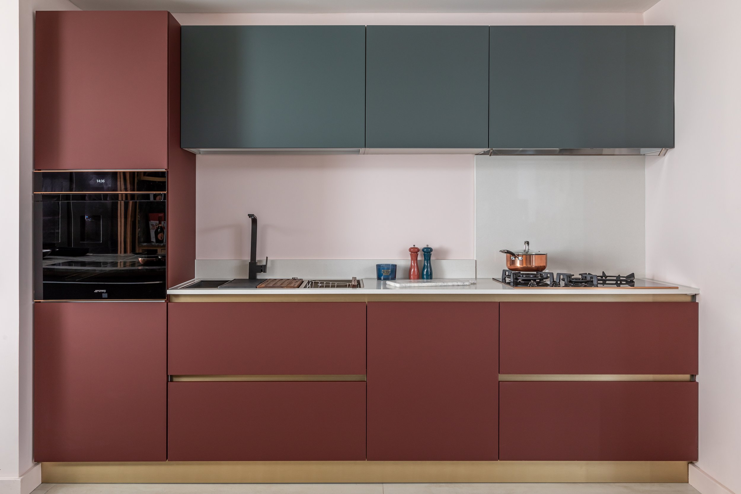 Modern kitchen with maroon cabinets, black faucet, stove, and oven