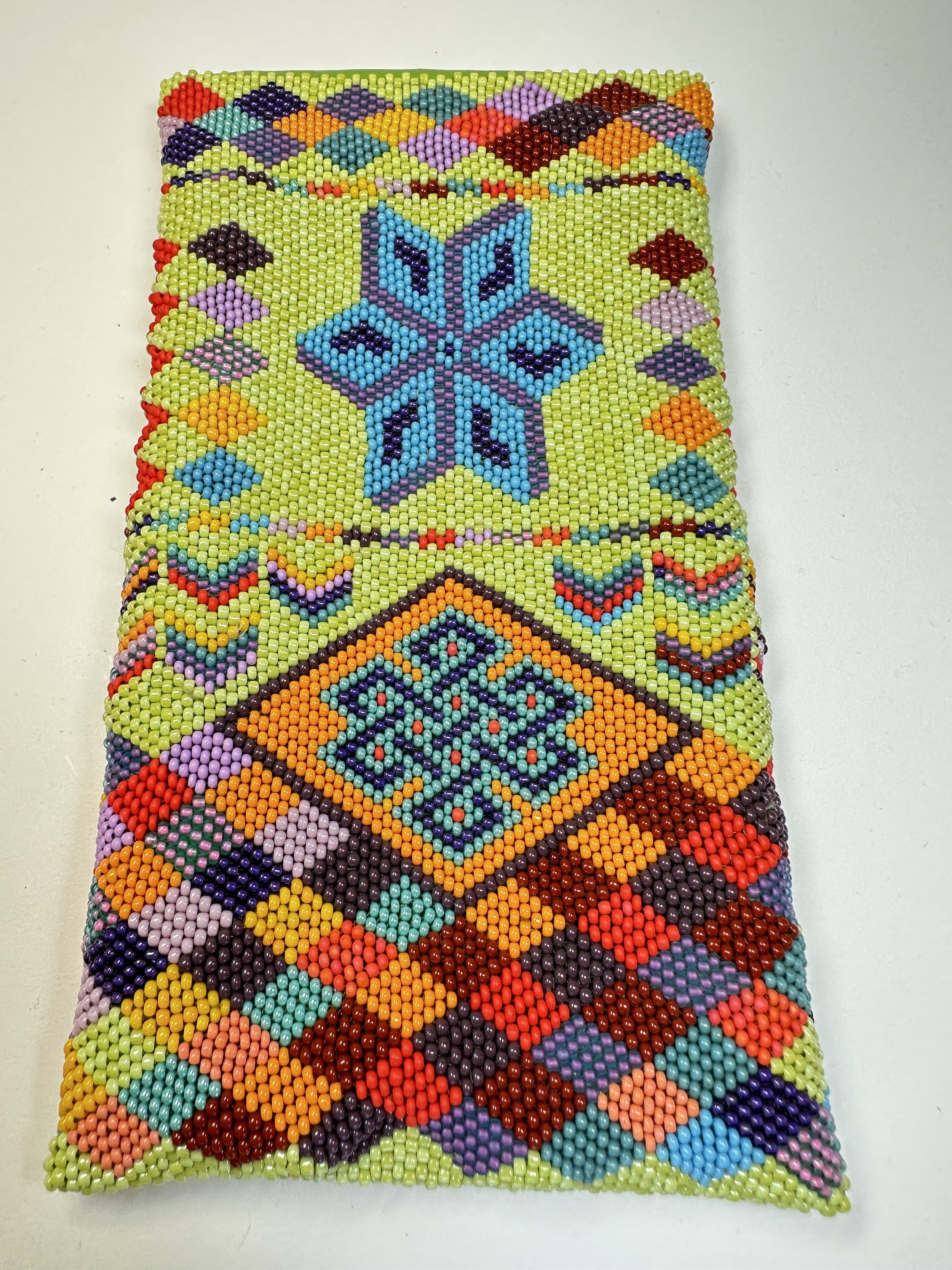 This is an eyeglasses case, beaded on both sides over a felt case. I never use pre-set patterns and bead the designs free handed. Creating the Celtic knot in the center was a challenge to do freehand! This piece took 45 hours to complete. 