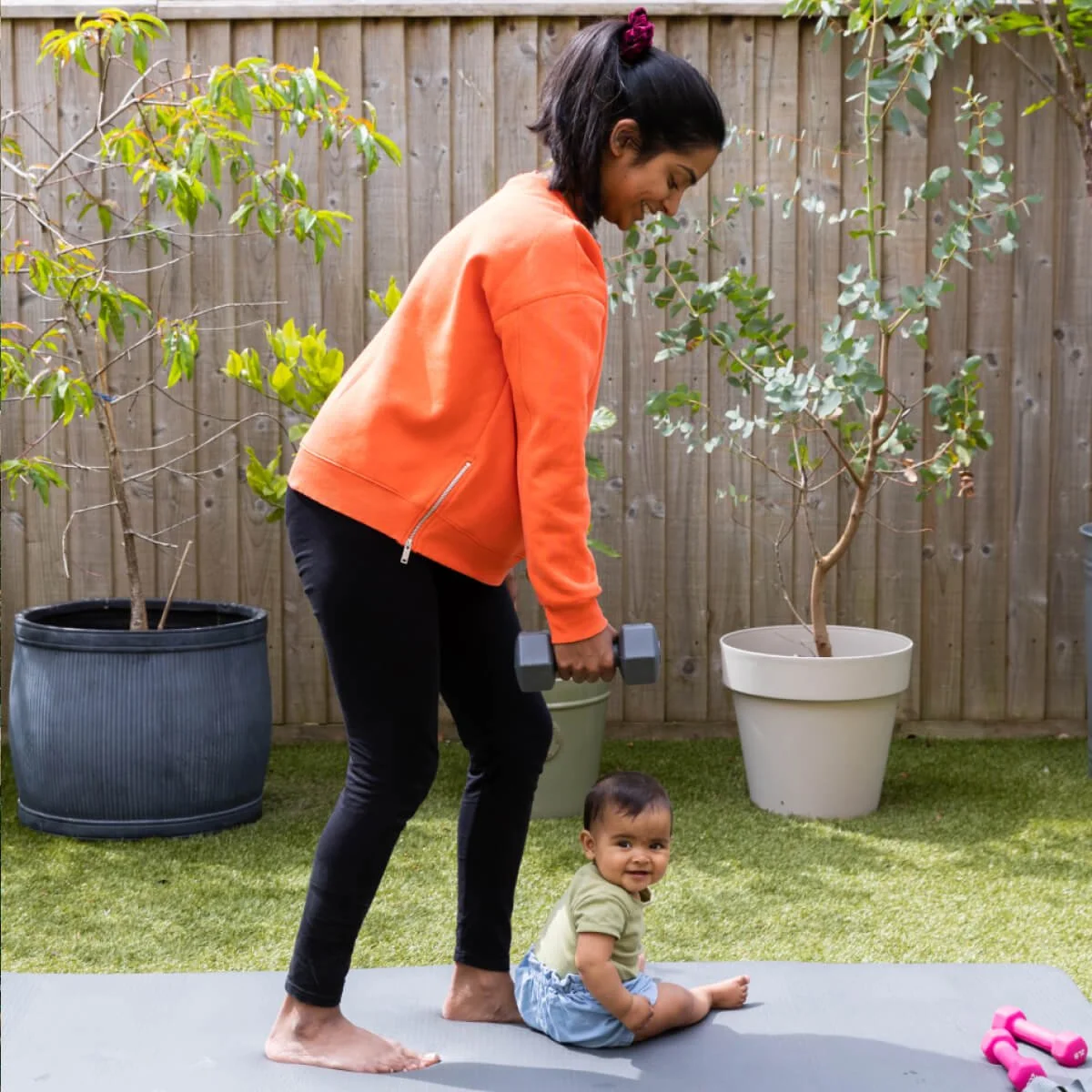 Nikita exercising in the garden with her toddler