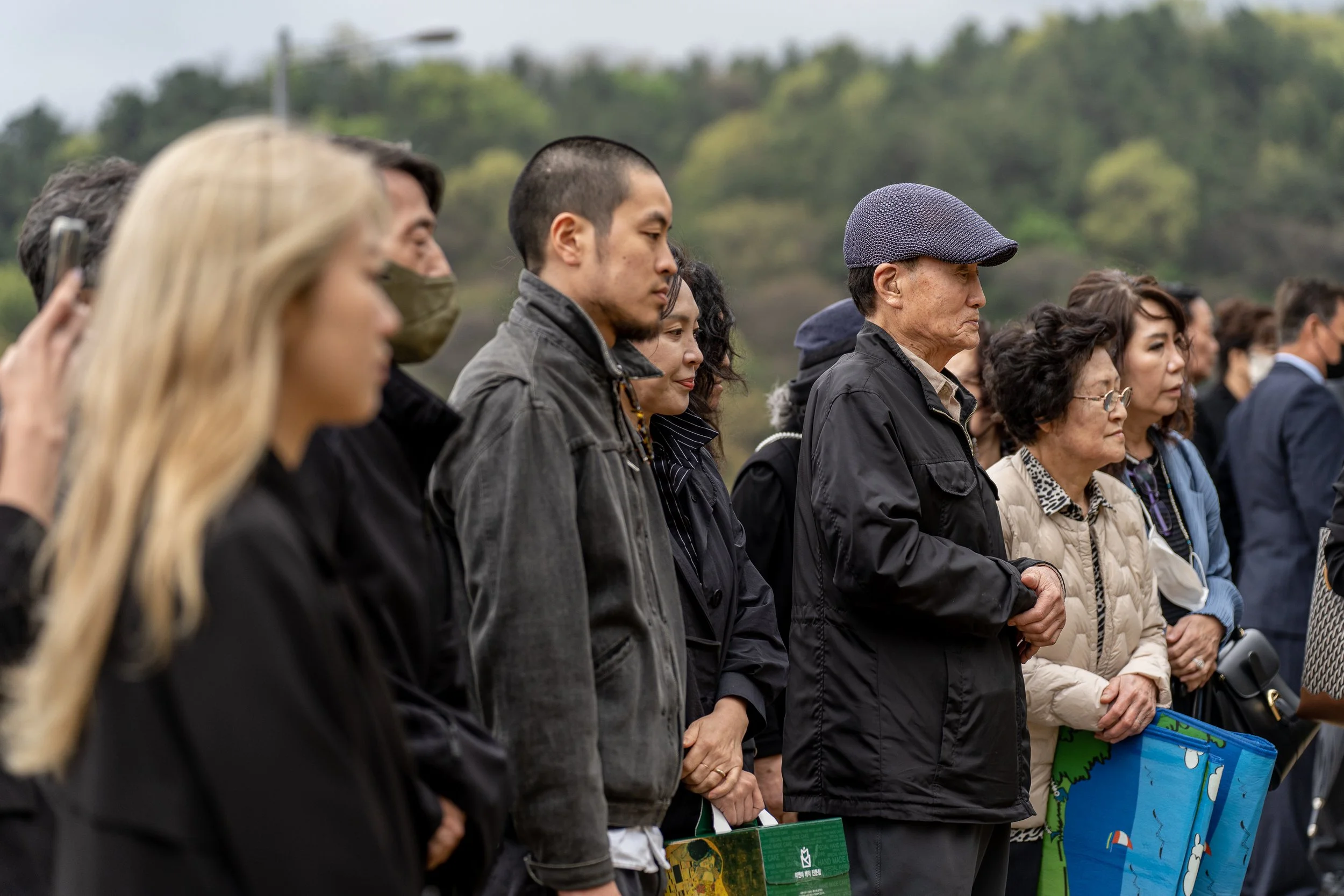 Lee family members look on as workers bury the urn holding Lee Jong-wook’s remains at Daejeon National Cemetery.