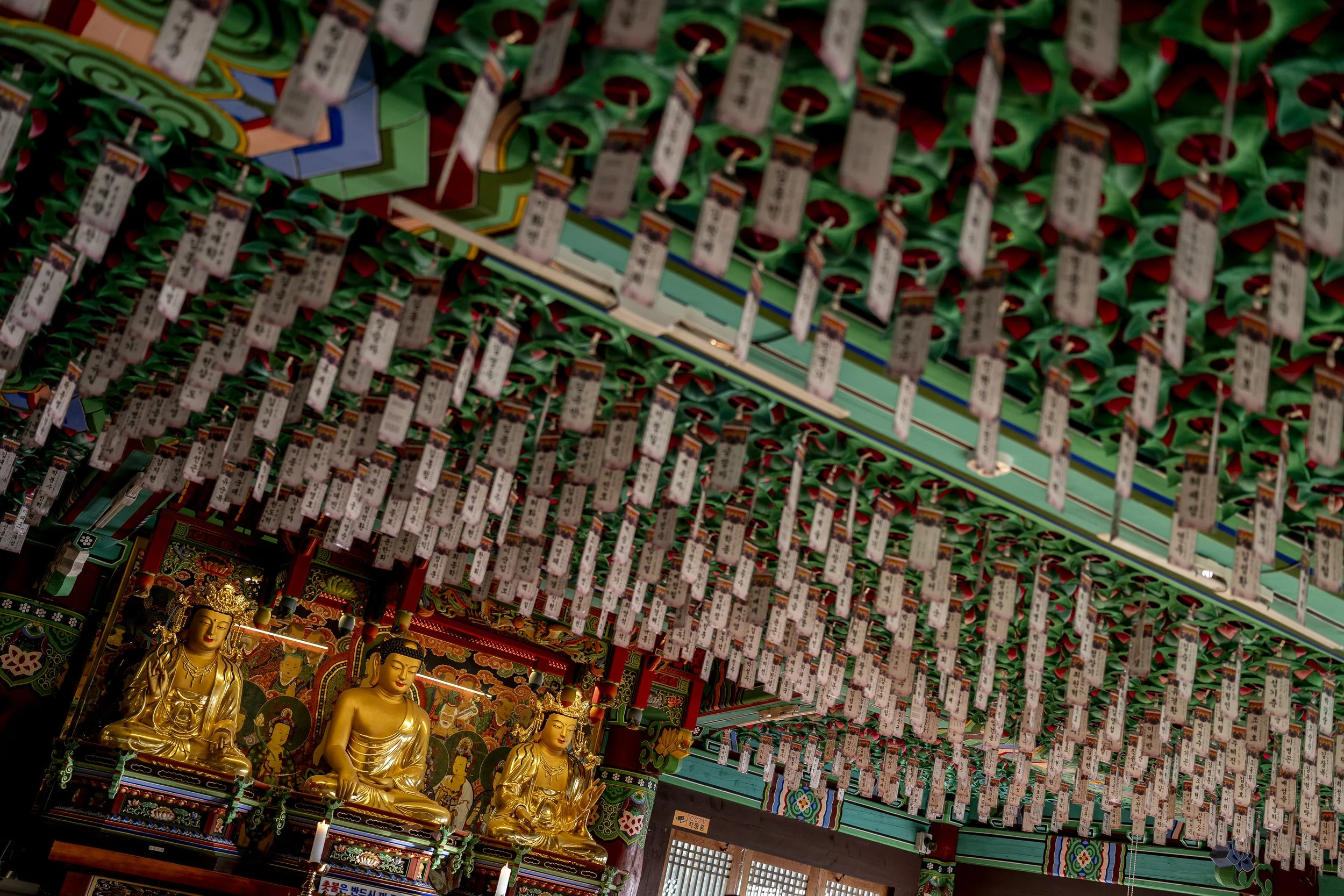 Statues and prayer cards adorn the interior of a temple hall at Eunhasa Temple.