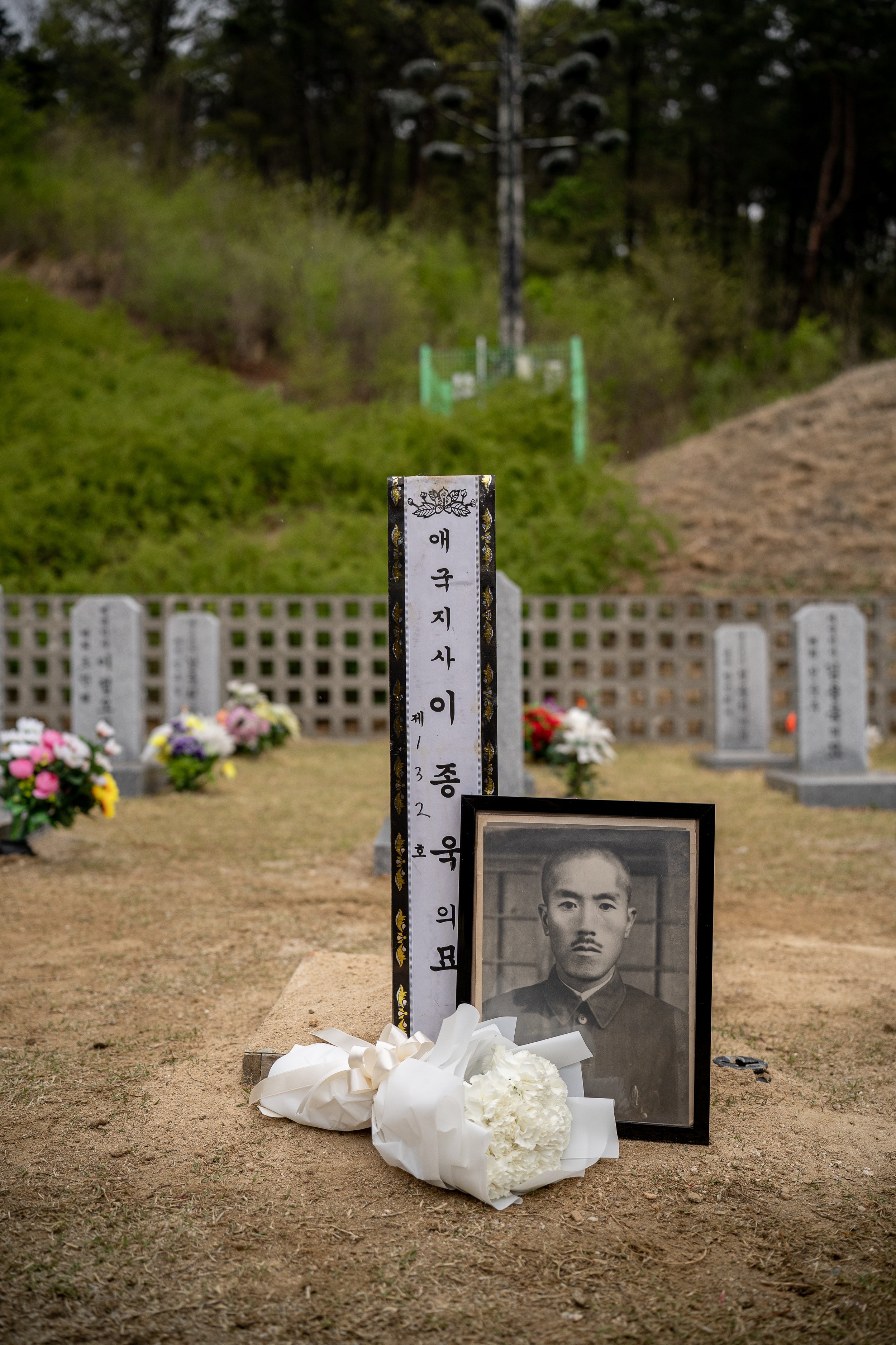 A portrait of Lee Jong-wook sits in front of his burial site at Daejeon National Cemetery in South Korea.