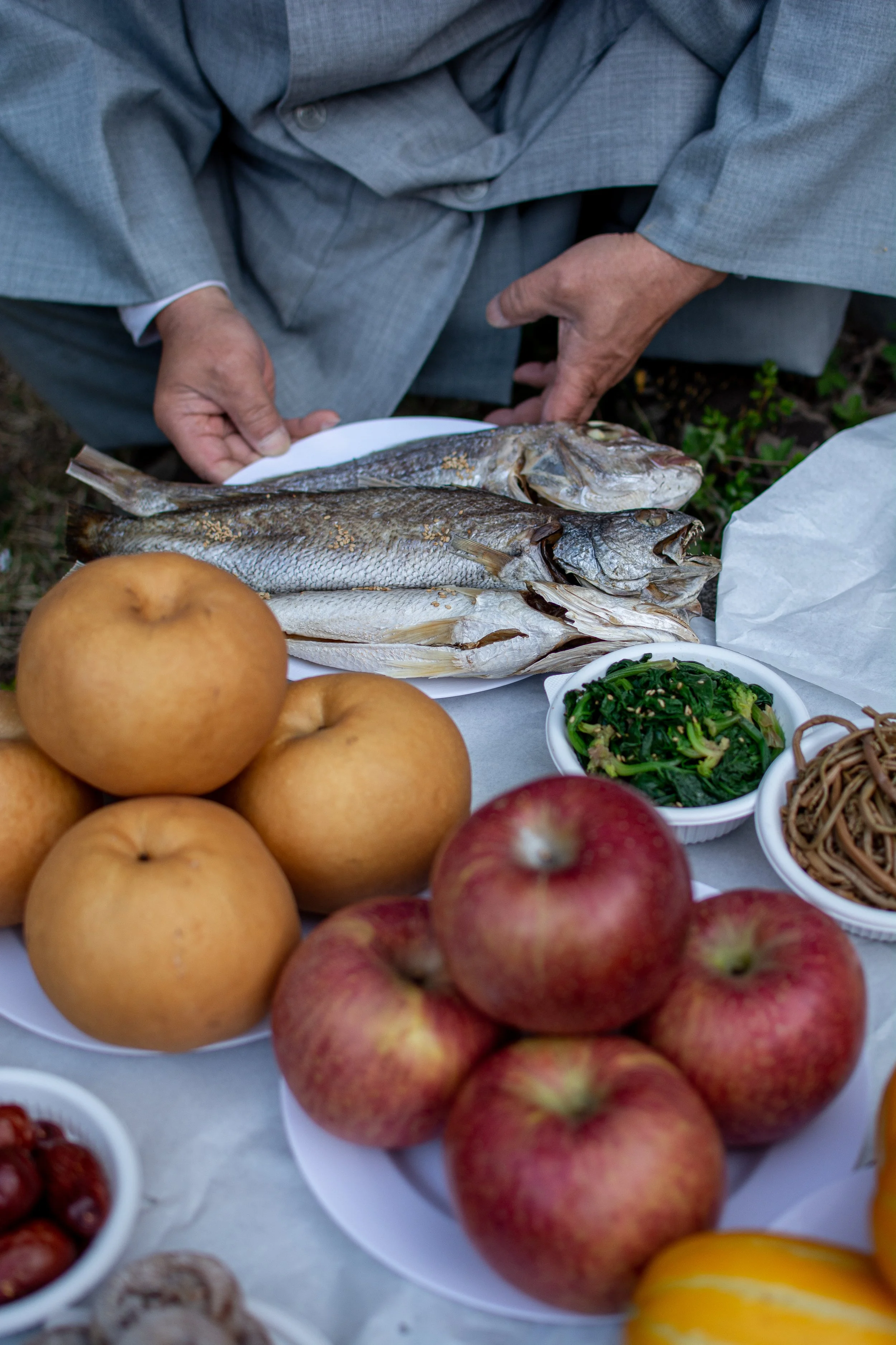 A monk sets food and alcohol for the blessing prayers ceremony in honor of Lee Jong-wook in Busan.