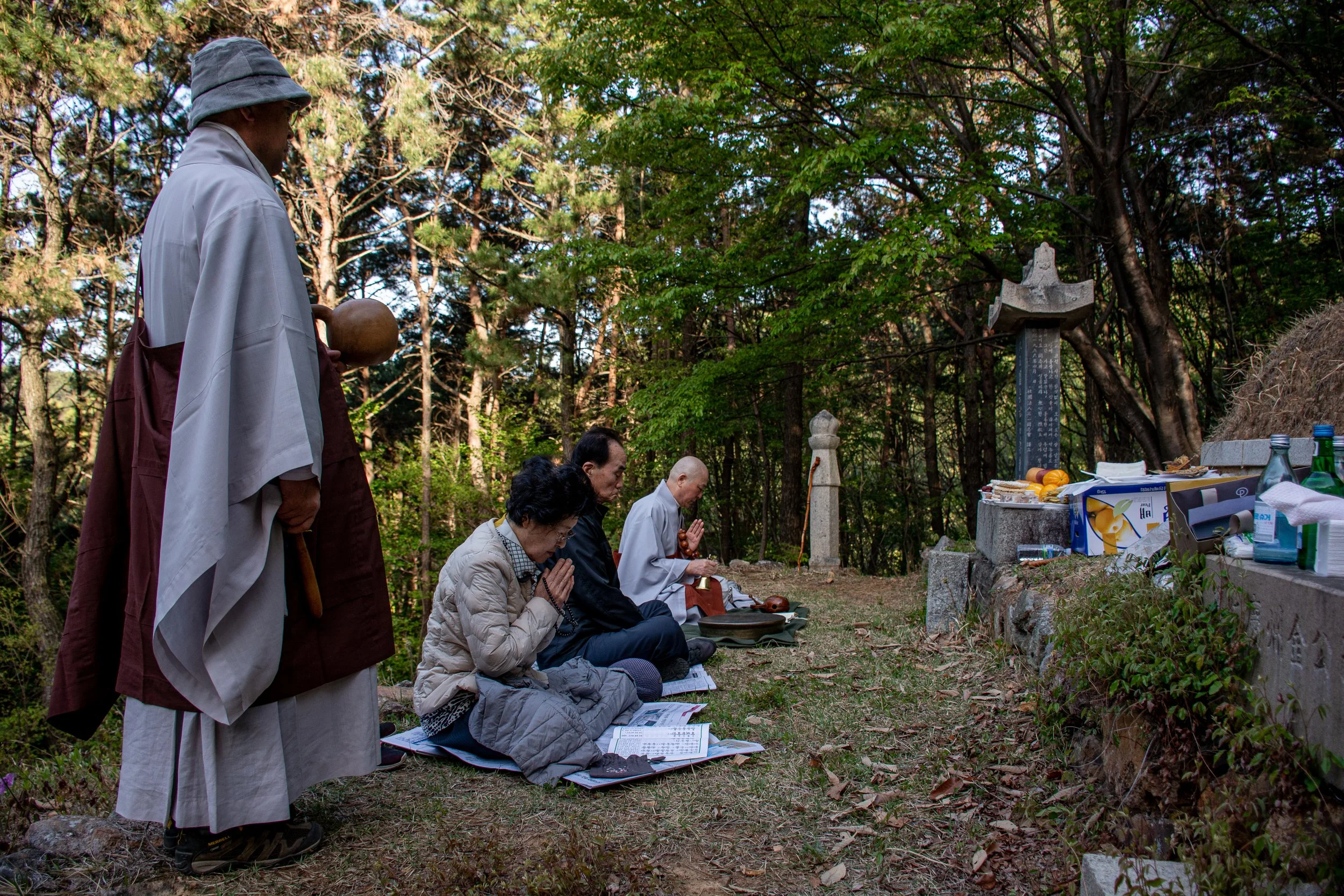 Buddhist monks perform blessing prayers in honor of Lee Jong-wook as the Lee family gathers at his original burial plot, in Busan.