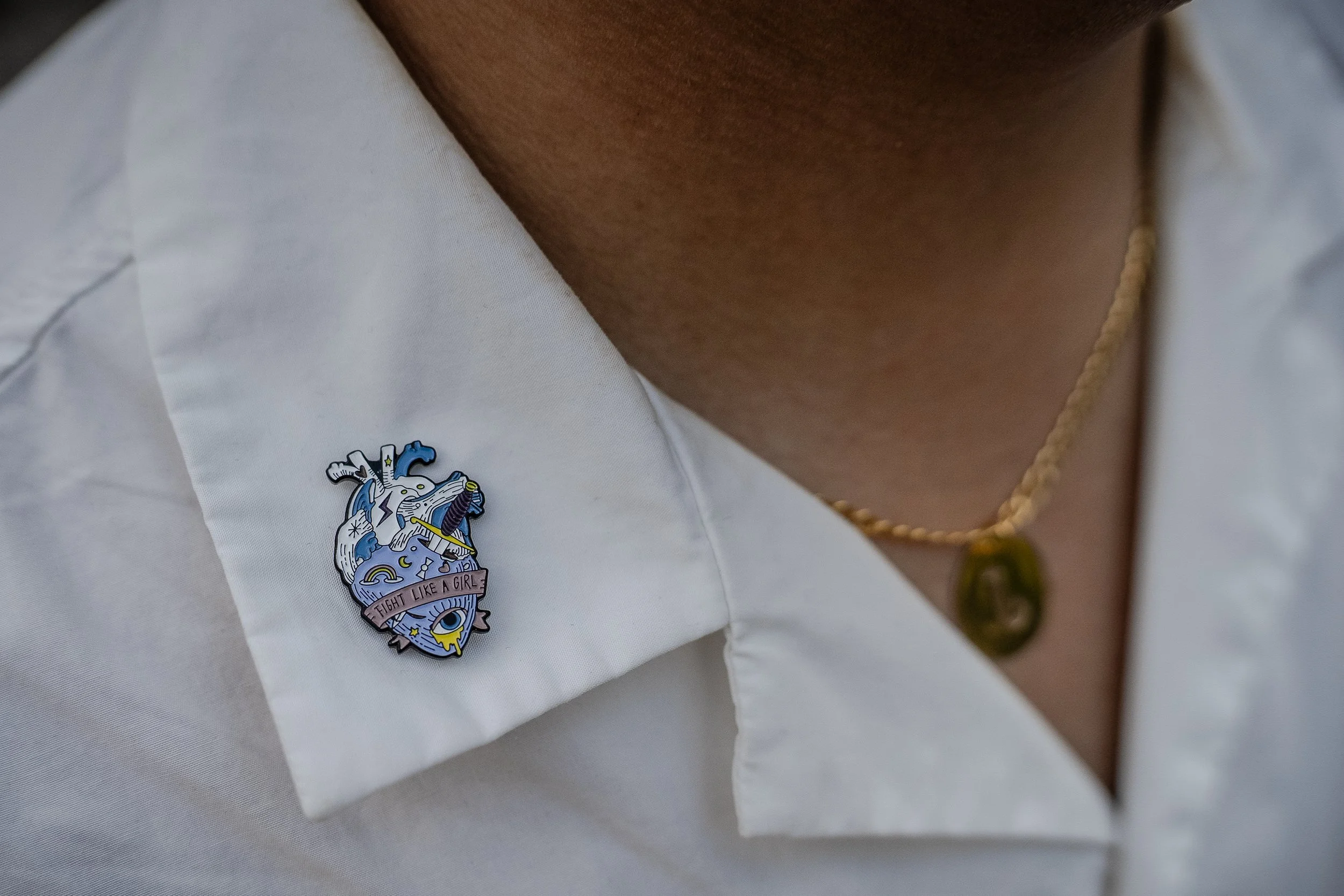 Jess Concepcion wears a pin that reads 'fight like a girl' as a reminder of the challenges he faced as a queer person growing up in the Philippines. 