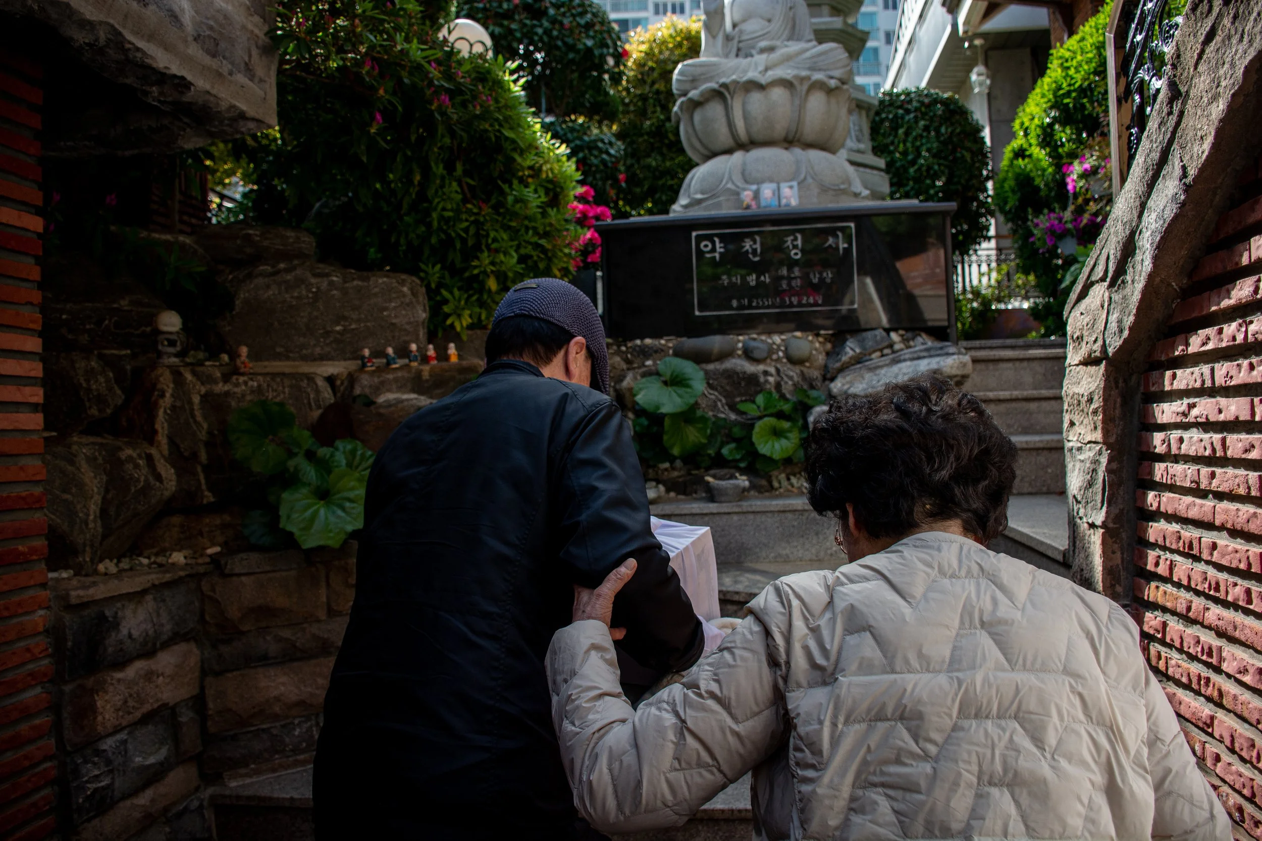 Yoon Tae-yun helps Lee Si-woo up the stairs at a temple in Busan.