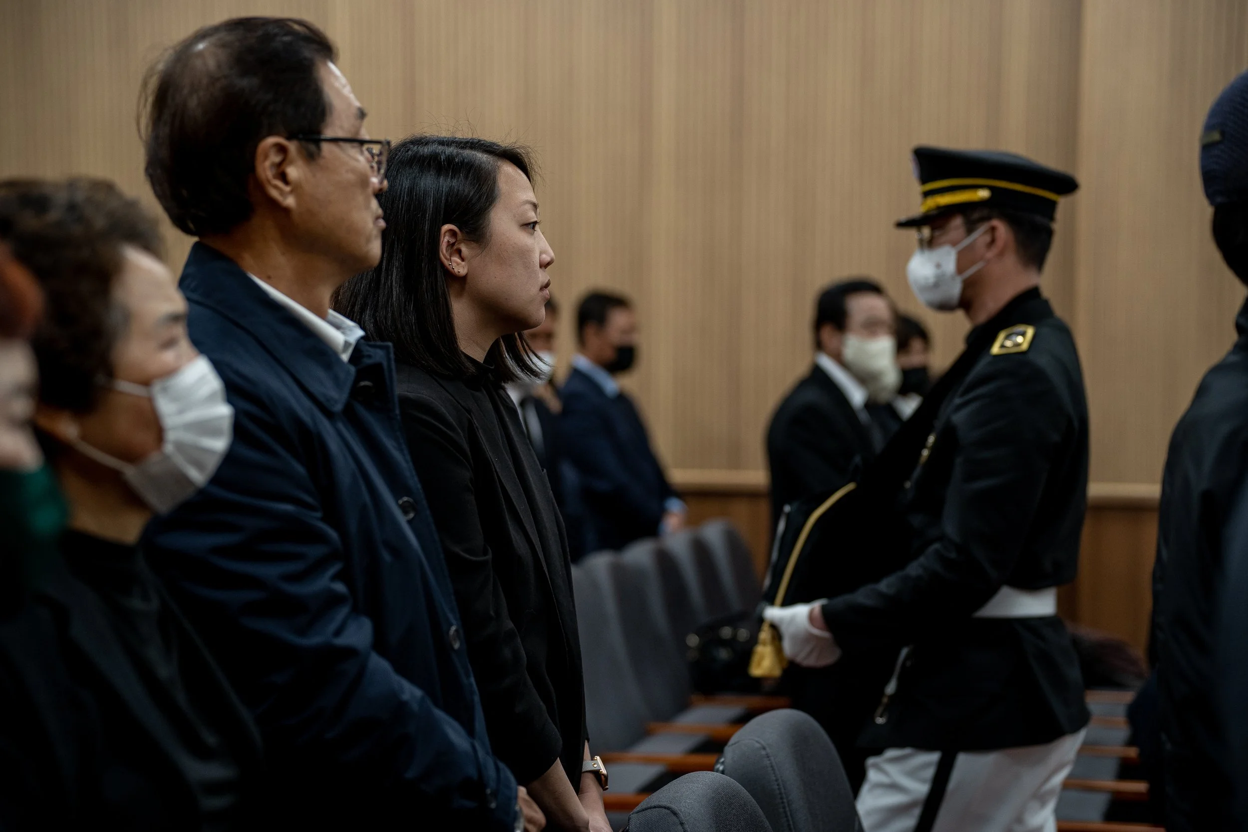 An honor guard carries urns past Michelle Ye Hee Lee and her family at the reinterring ceremony at Daejeon National Cemetery.