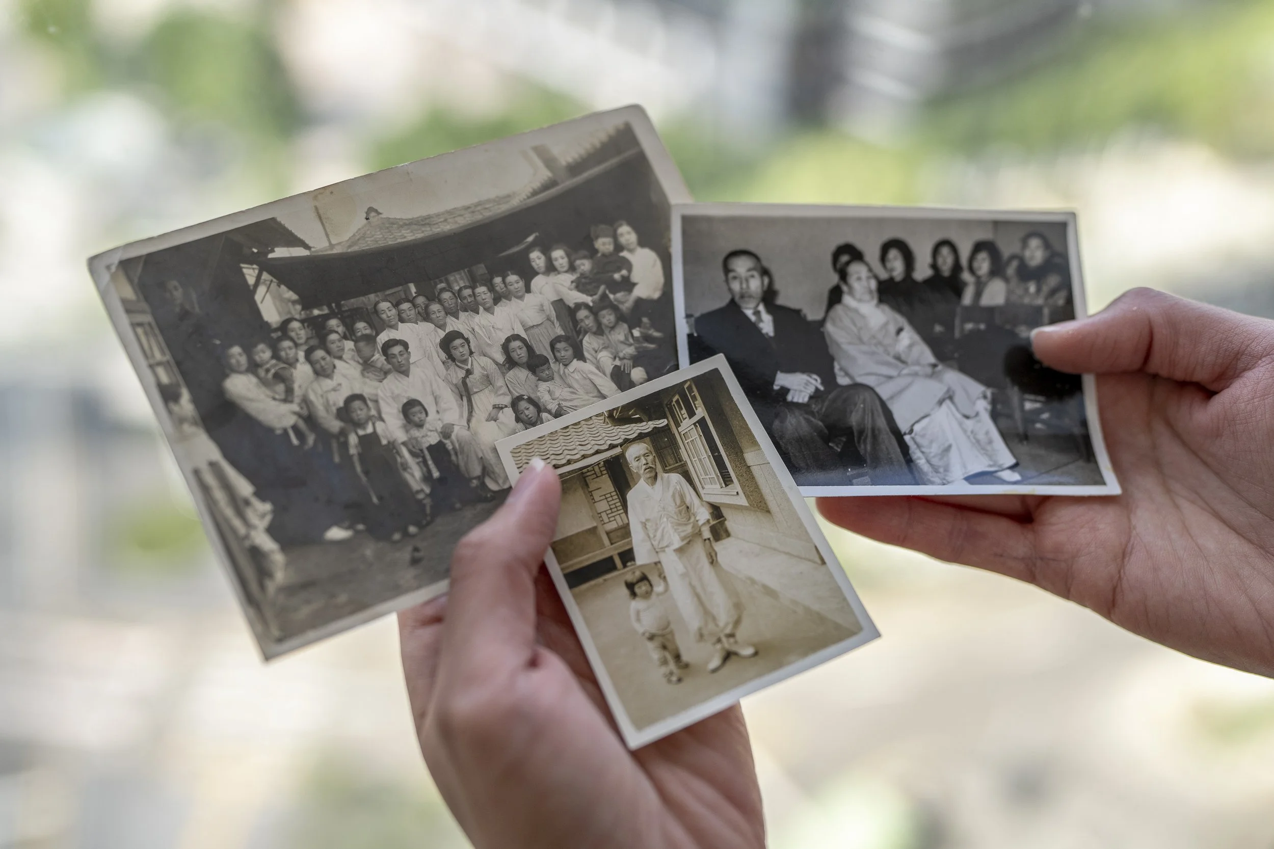 Washington Post correspondent Michelle Ye Hee Lee holds old family photos in Seoul.