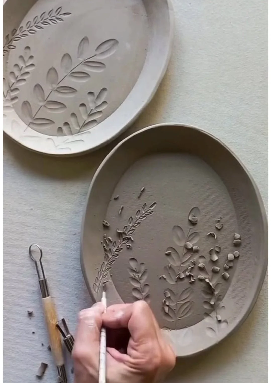 Handmade clay serving bowl with floral carving design.