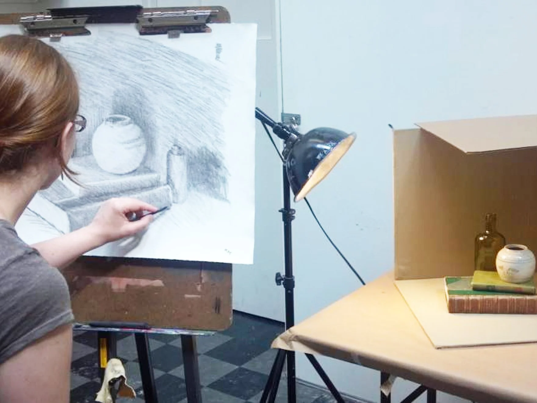 Student drawing a still life in a classroom setting.jpg