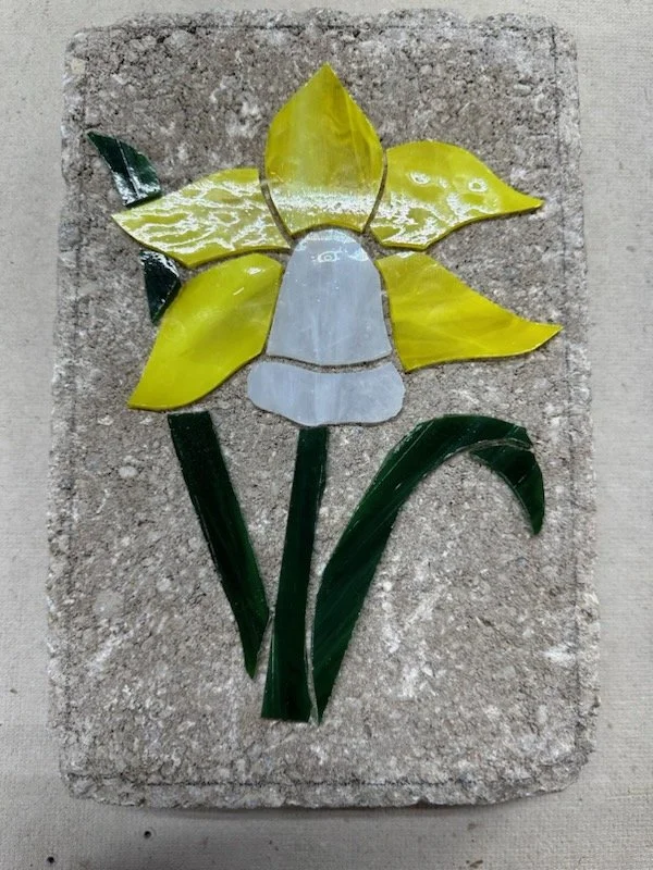 Mosaic stepping stone with a daffodil.