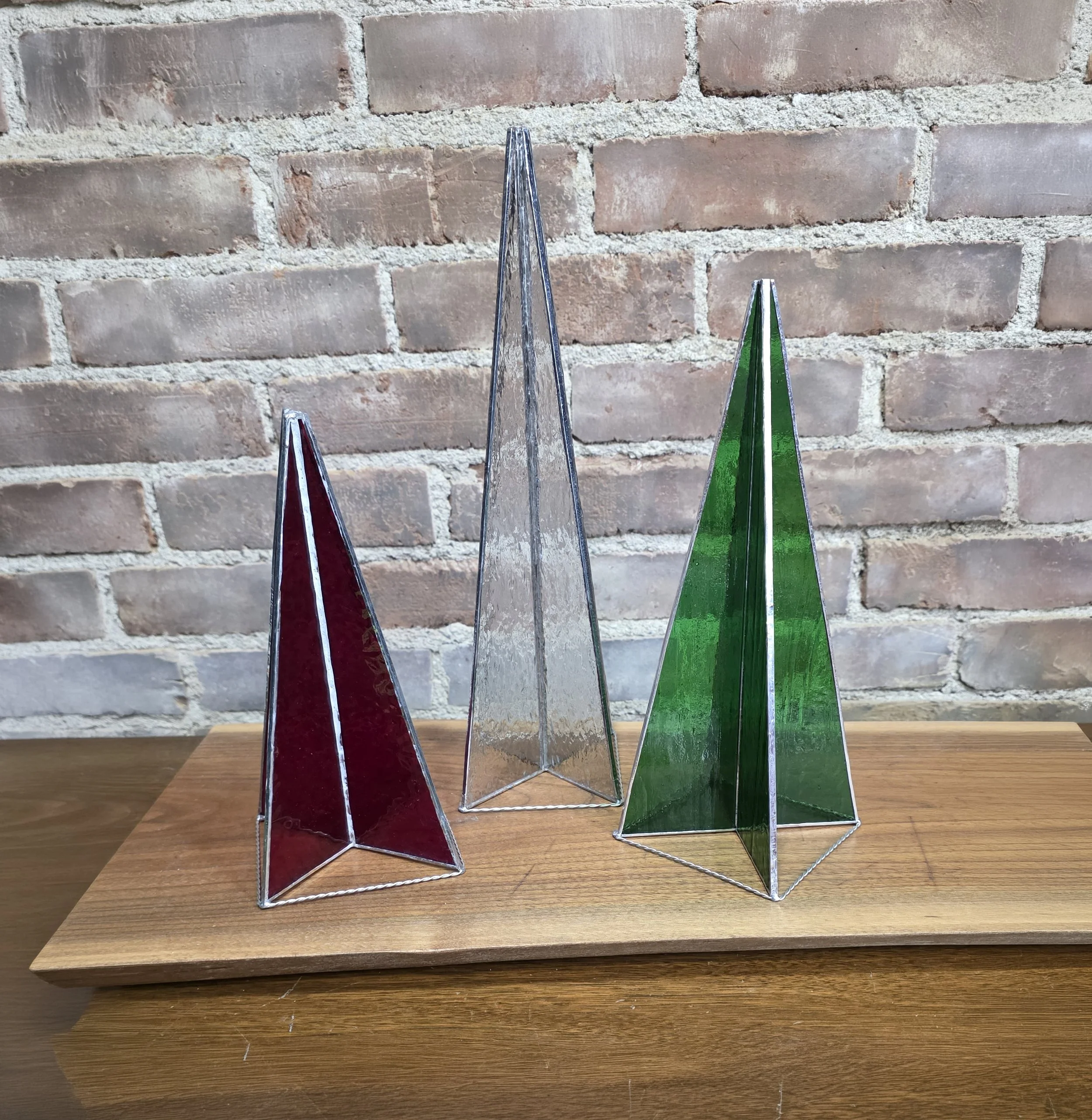 Three stained glass tree spires with red, green, and clear glass.