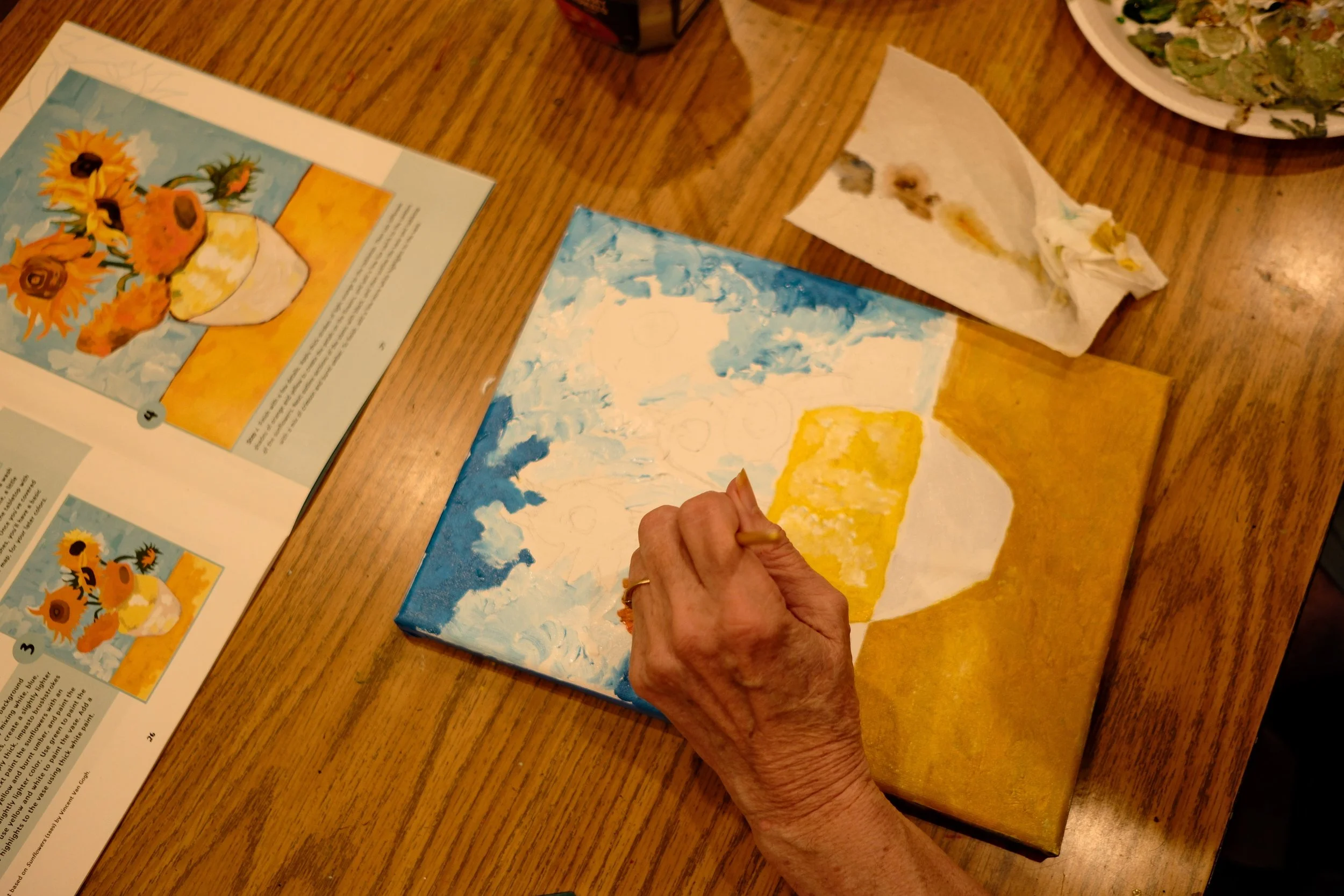 Hand painting a sunflower still life in acrylic paint.