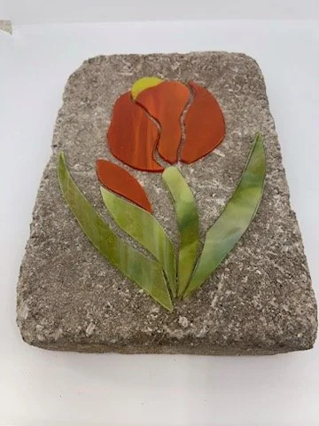 Mosaic stepping stone with orange tulip design.