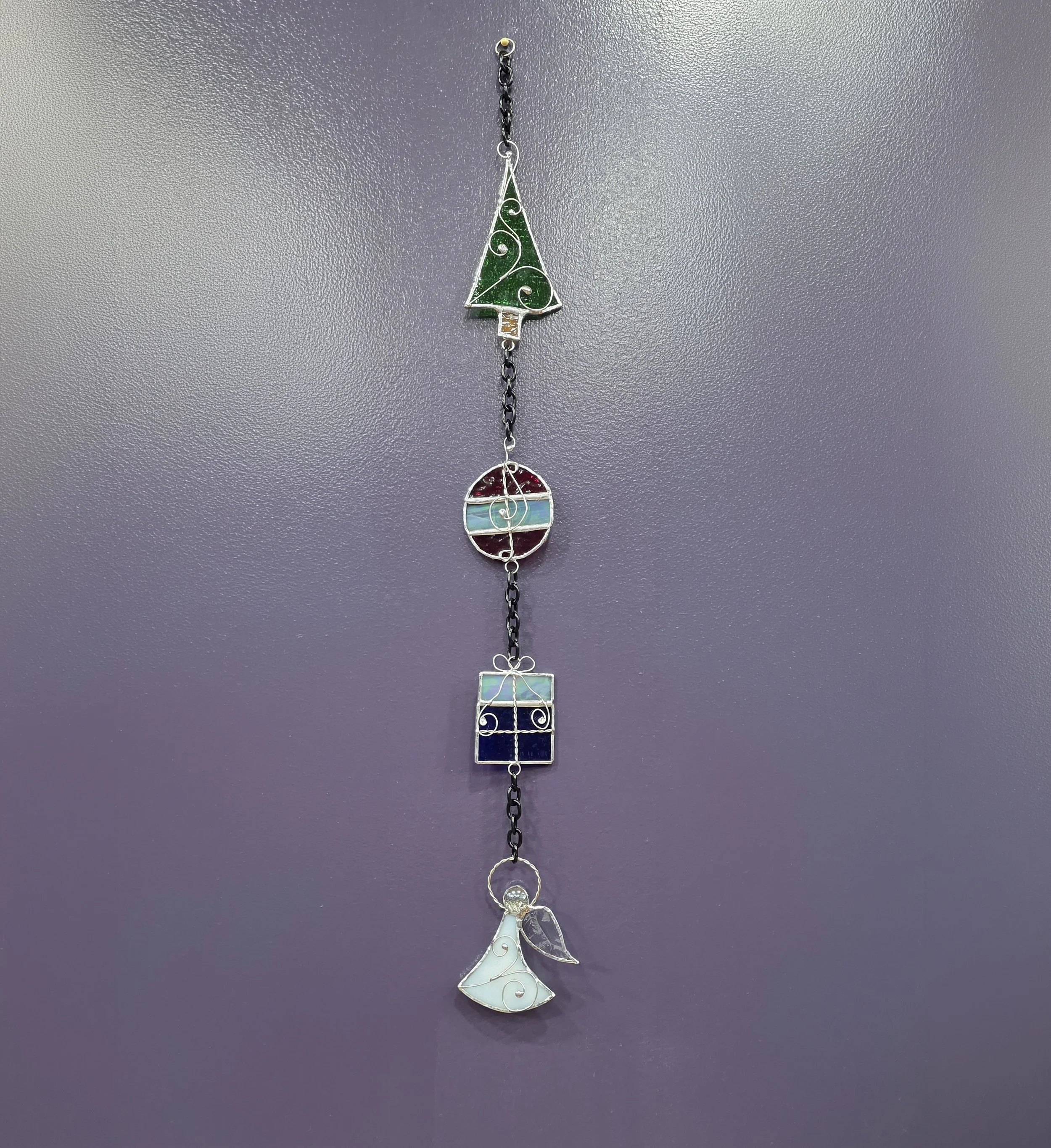 Stained glass Christmas chain featuring four stained glass pieces: Tree, bulb, present, and angel.