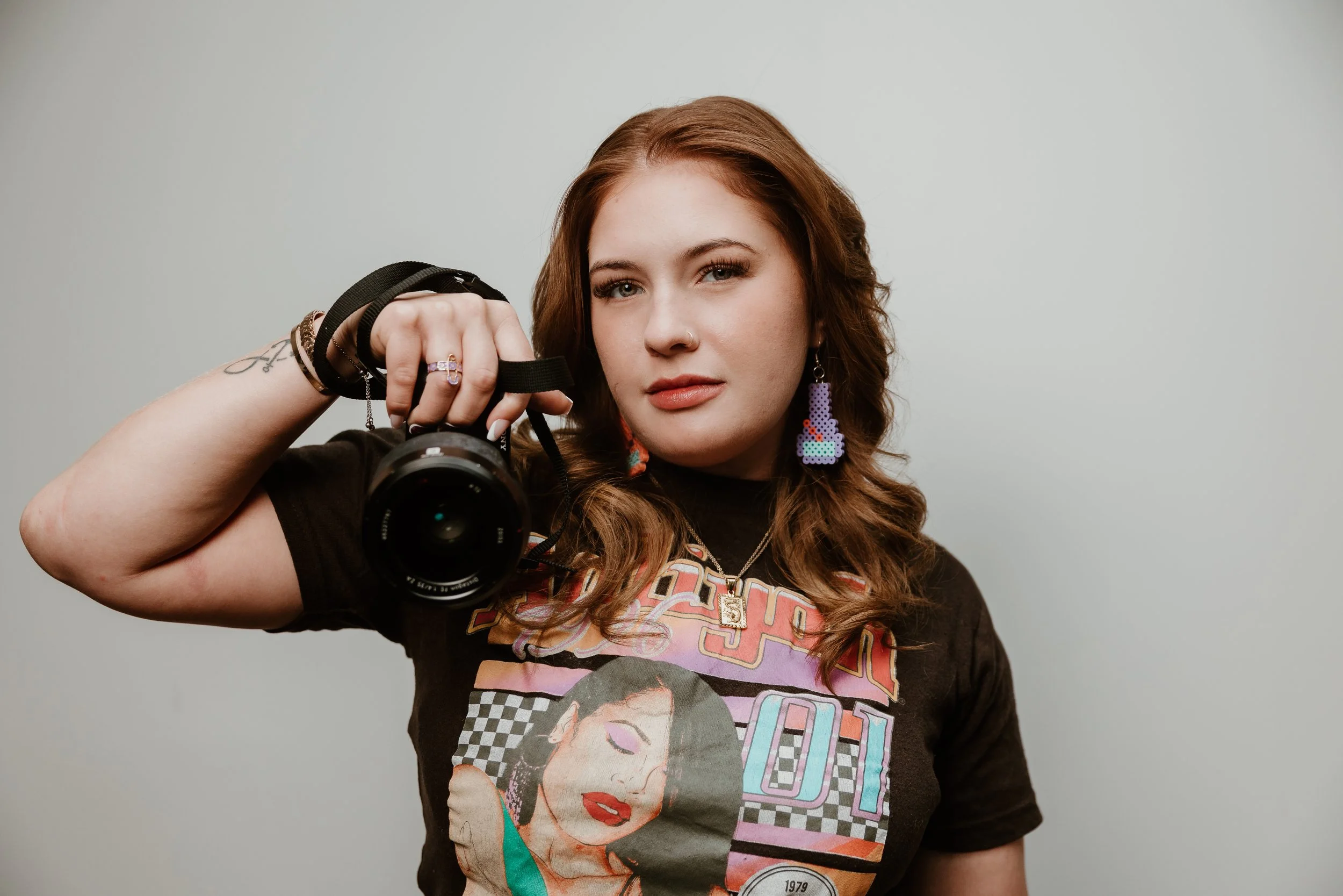 Portrait of Alia Cecil, creative director of AKay, holding a camera.