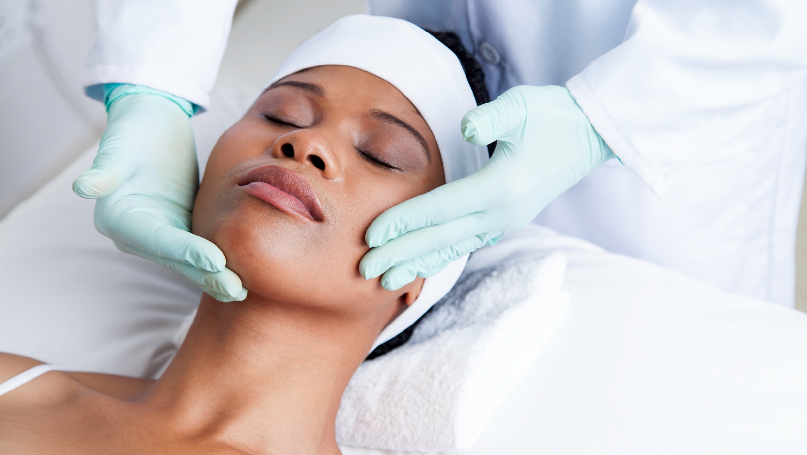 Close-up of a woman receiving a facial massage from a professional in a spa or skincare clinic.