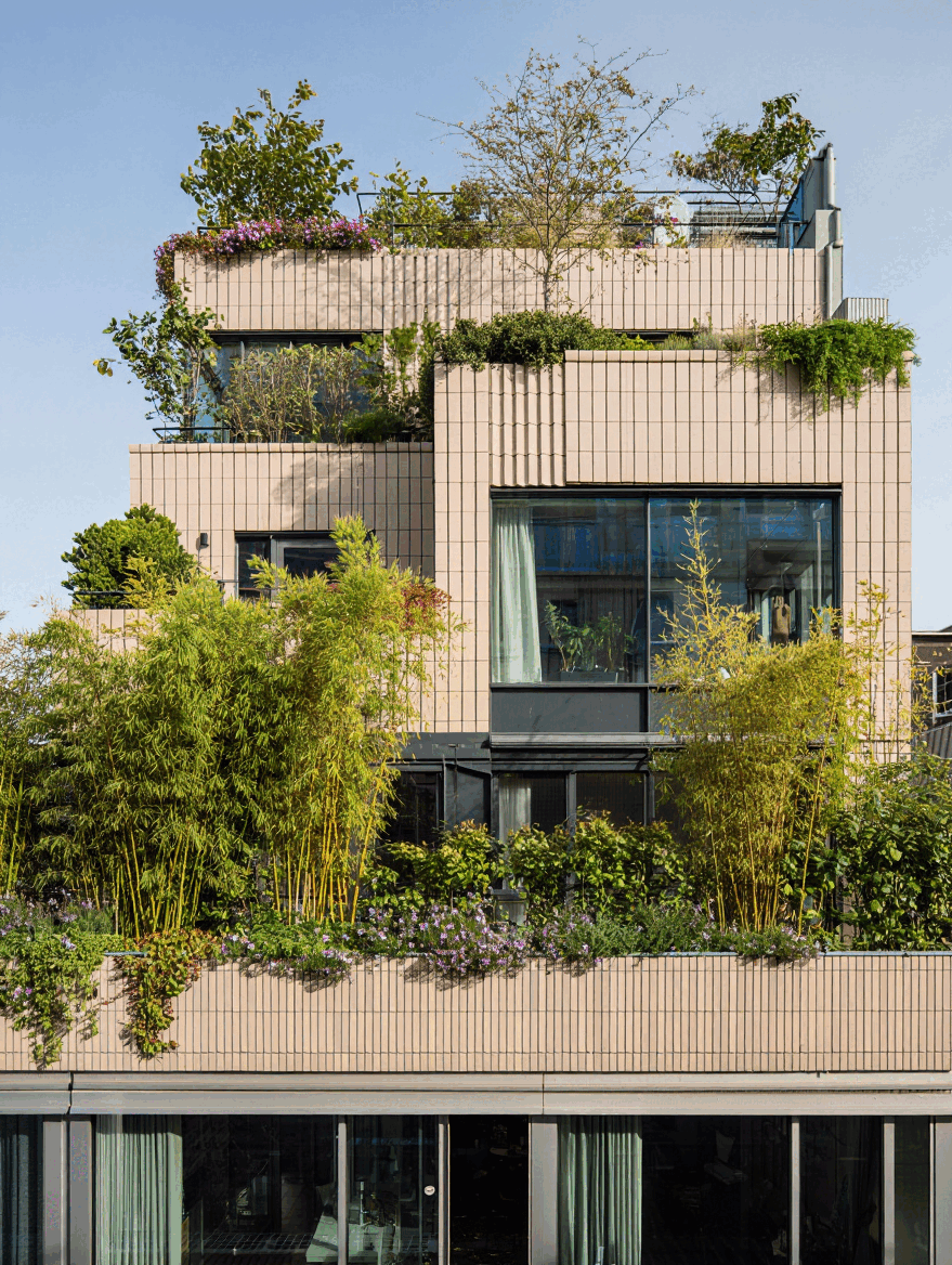 Bygning med grønne planter på altaner og tagterrasse