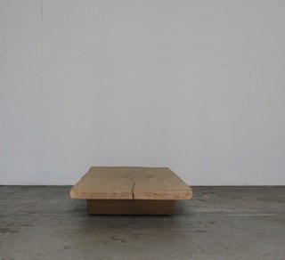 Minimalist wooden platform or low bench against a plain wall.