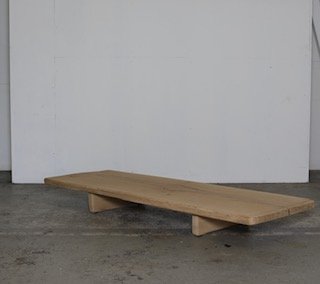Wooden low platform or bench with a minimalist design on a concrete floor