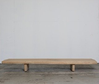 Minimalist wooden bench against a light background.