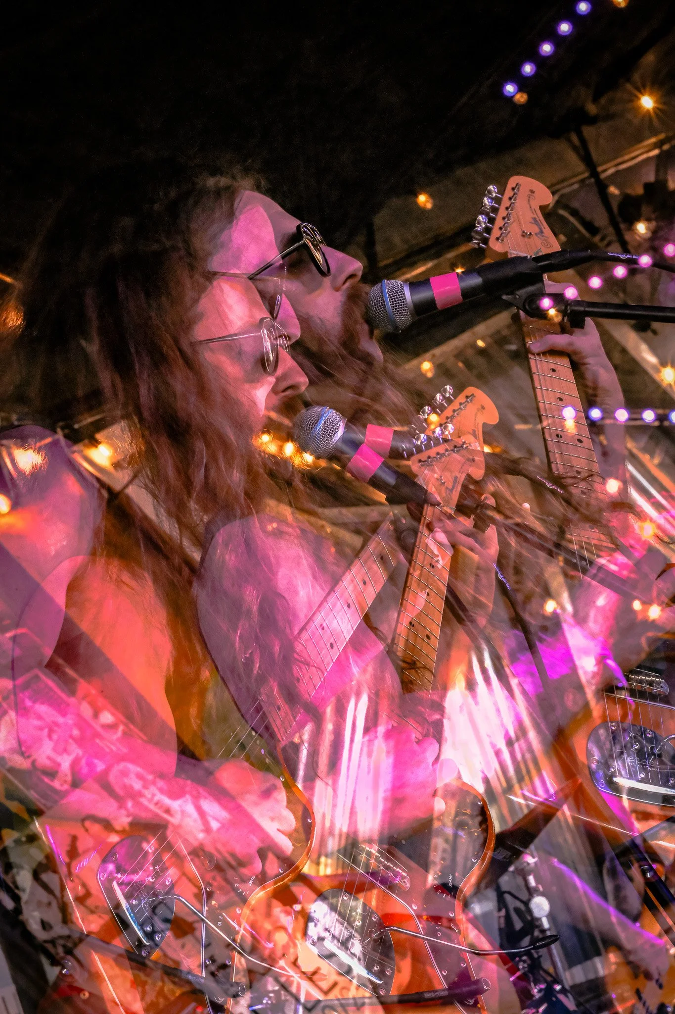 Multiple layered images of a band performing on stage with guitars, microphones, and stage lights at night.