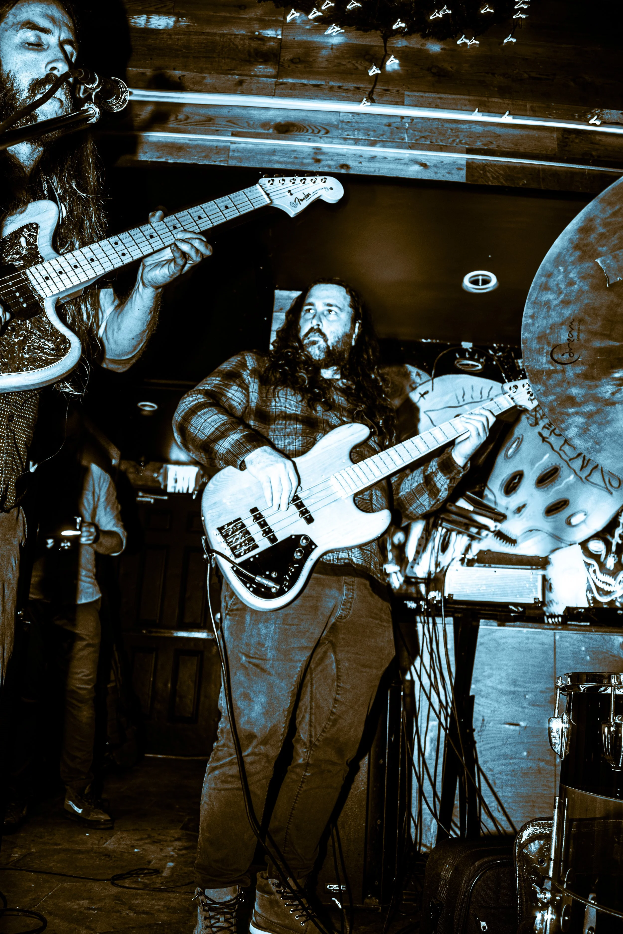Chas Binns and Tysonious Mink of the rock band LIquid Pennies play guitar and bass at a live show.