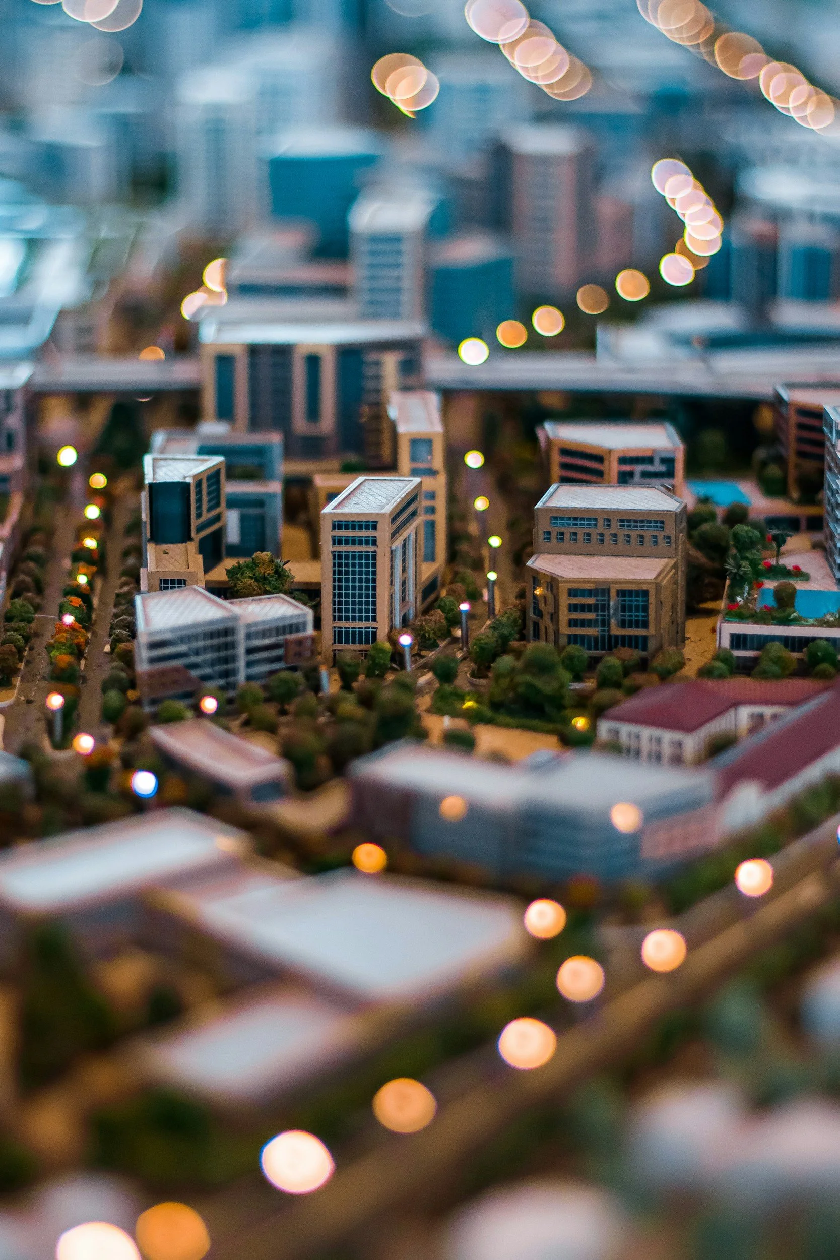 Blurred cityscape with buildings and string lights.