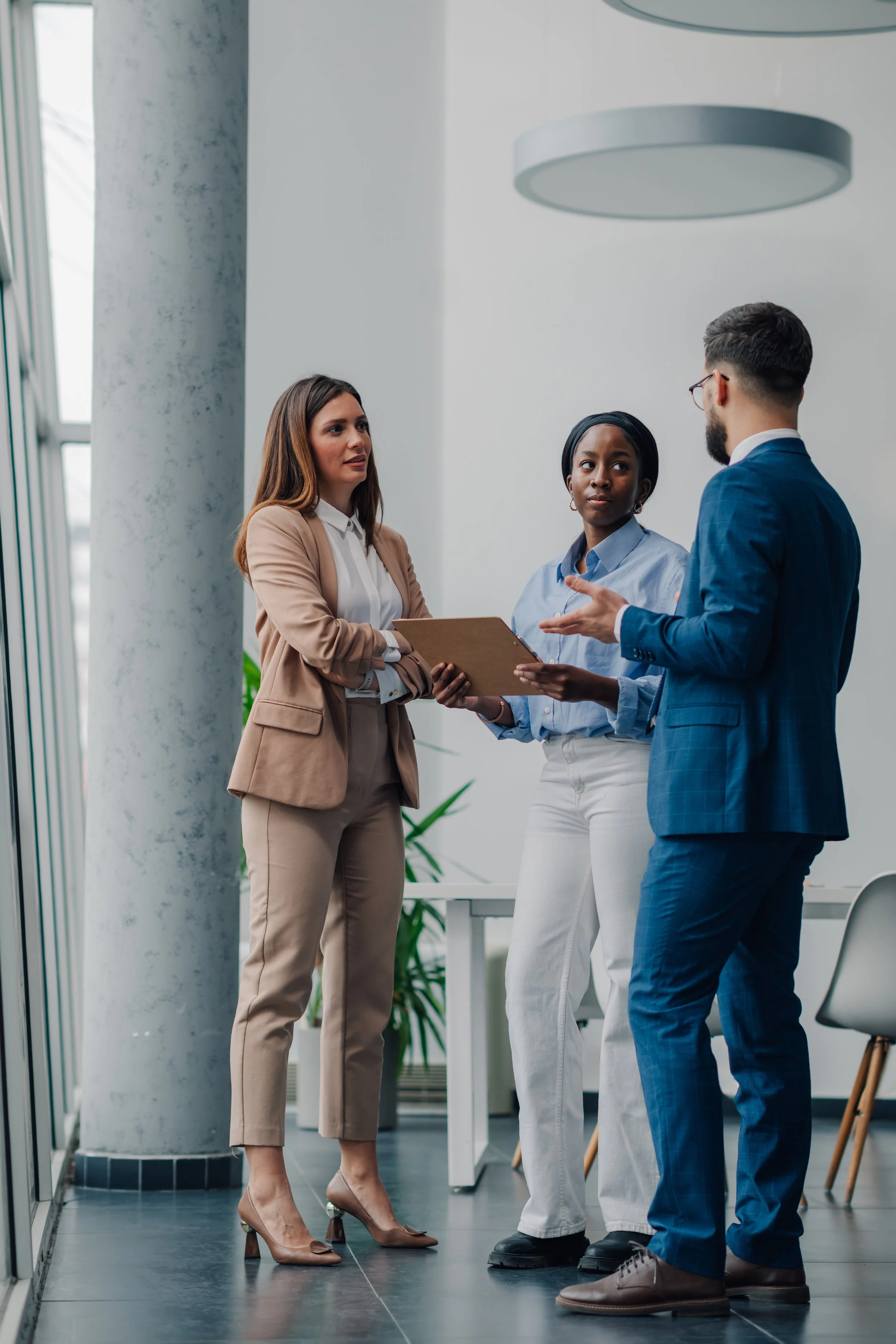 Three professionals having a discussion in an office.