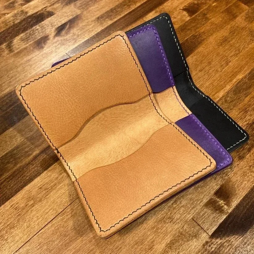 Three hand-stitched leather wallets.