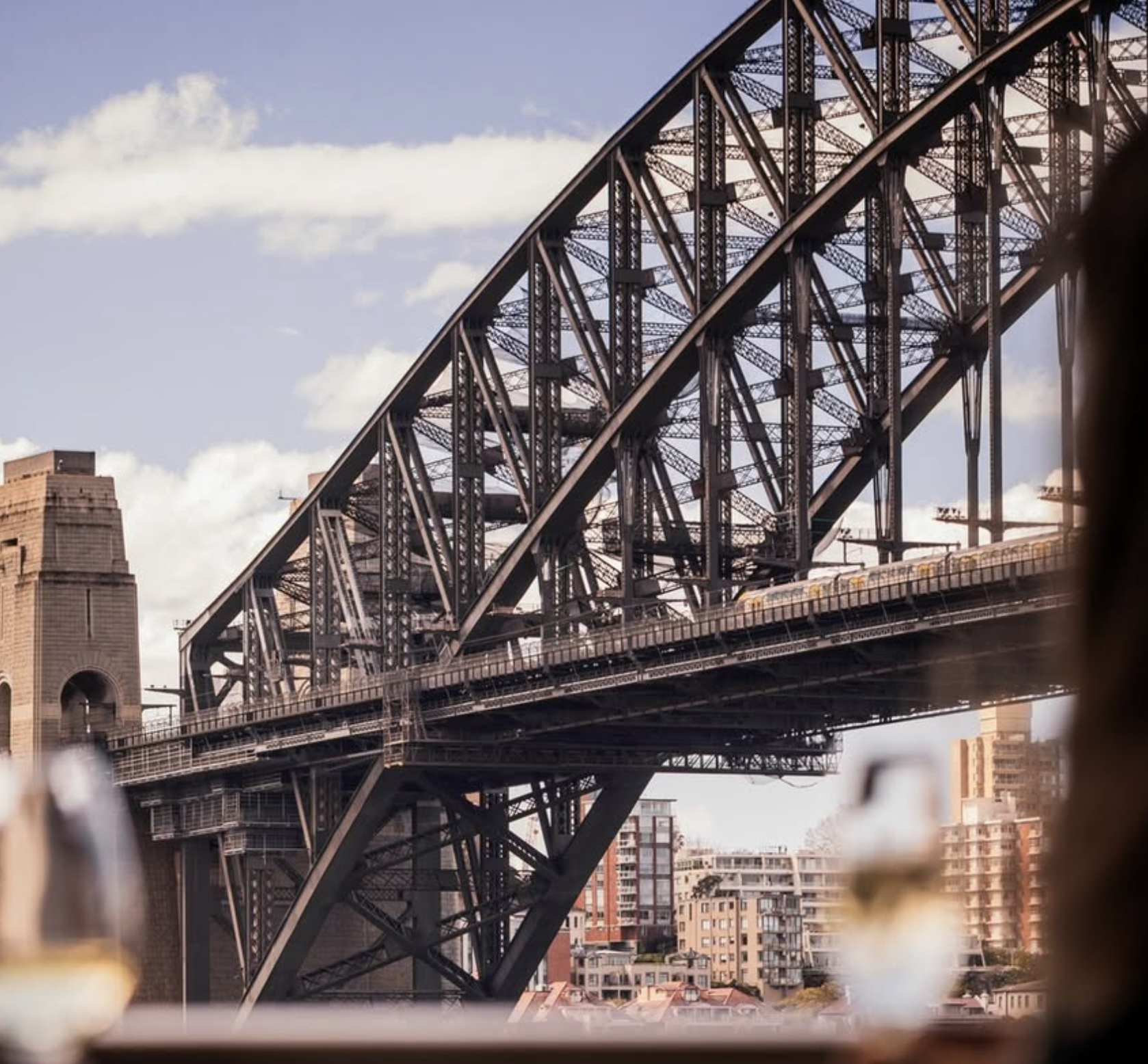 View of the Sydney Harbour Bridge with part of the city skyline in the background during daytime.