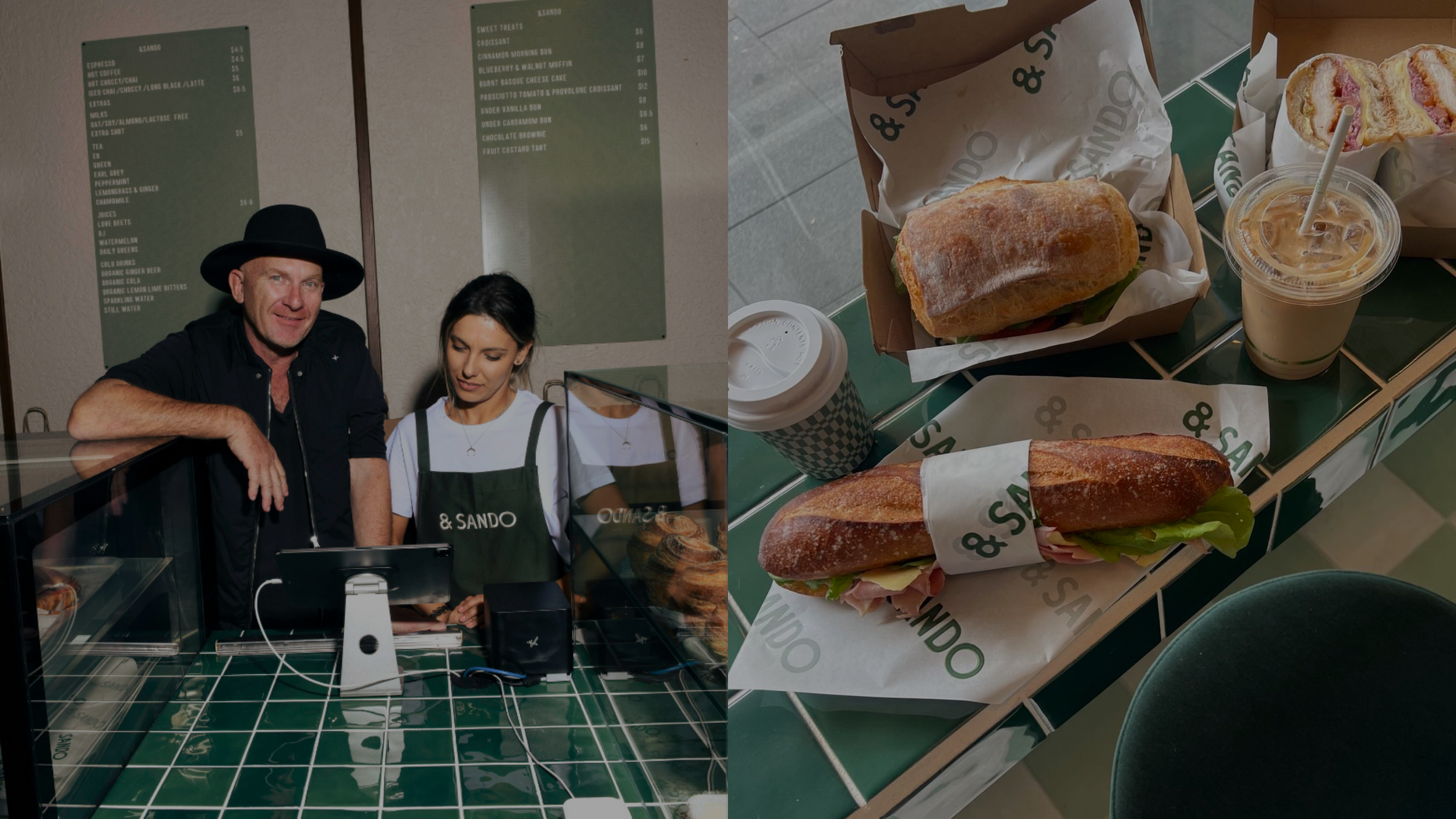 Two people standing behind a counter at a cafe, with a green menu on the wall behind them; on the right, three sandwiches wrapped in paper, a drink with a straw, a cup with a lid, and a pastry on a green-tiled table.