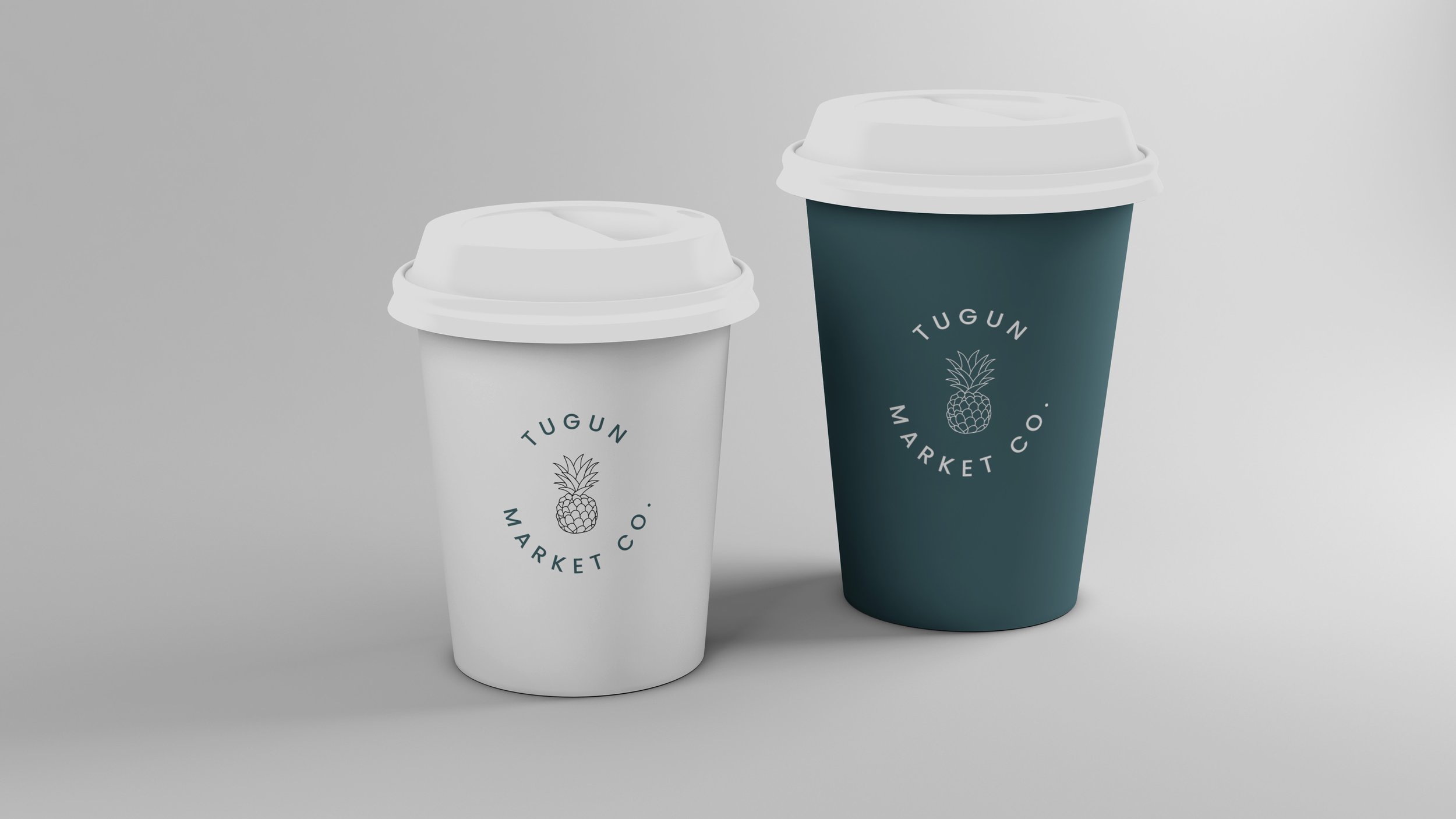 Two disposable coffee cups with white plastic lids, one white and one dark teal, with the logo 'Tugun Market Co.' and a pineapple illustration.